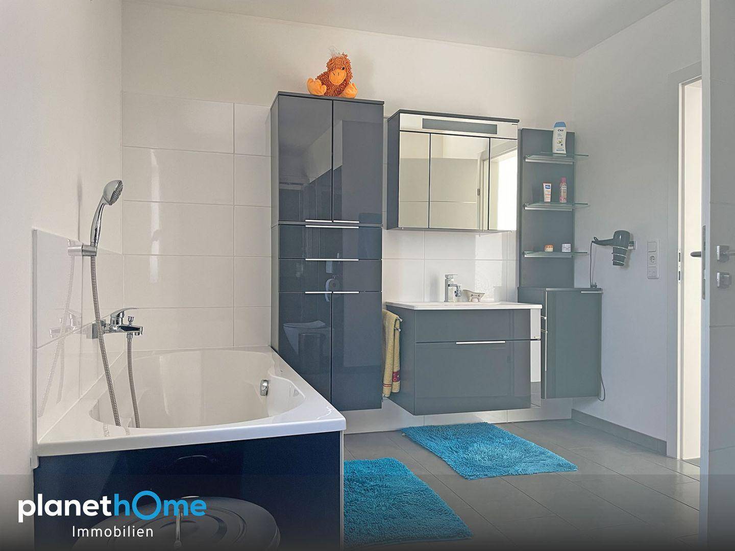 Geräumiges Badezimmer mit Badewanne, Doppelwaschbecken und modernen Badmöbeln.