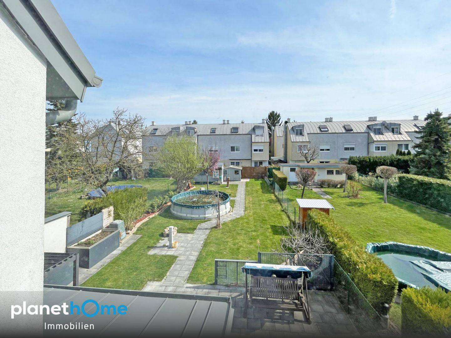 Weitblick vom Fenster über den Garten mit Pool und die umliegende Wohnsiedlung.
