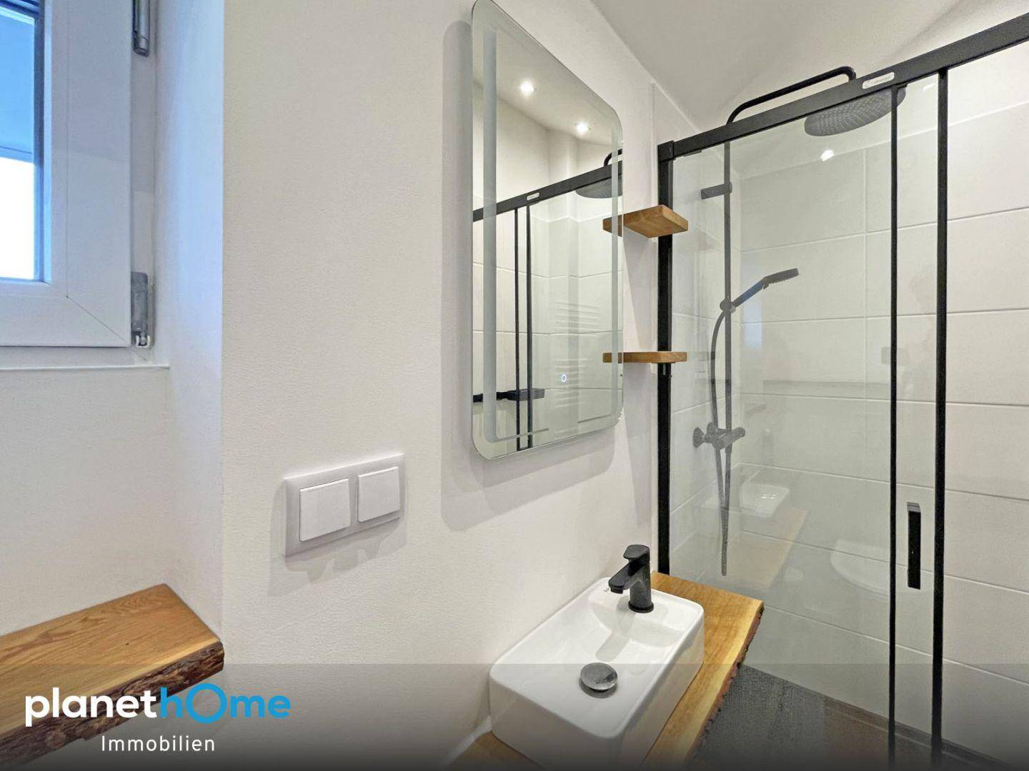 Modernes Gäste-WC mit Dusche, Aufsatzwaschbecken und Spiegel.