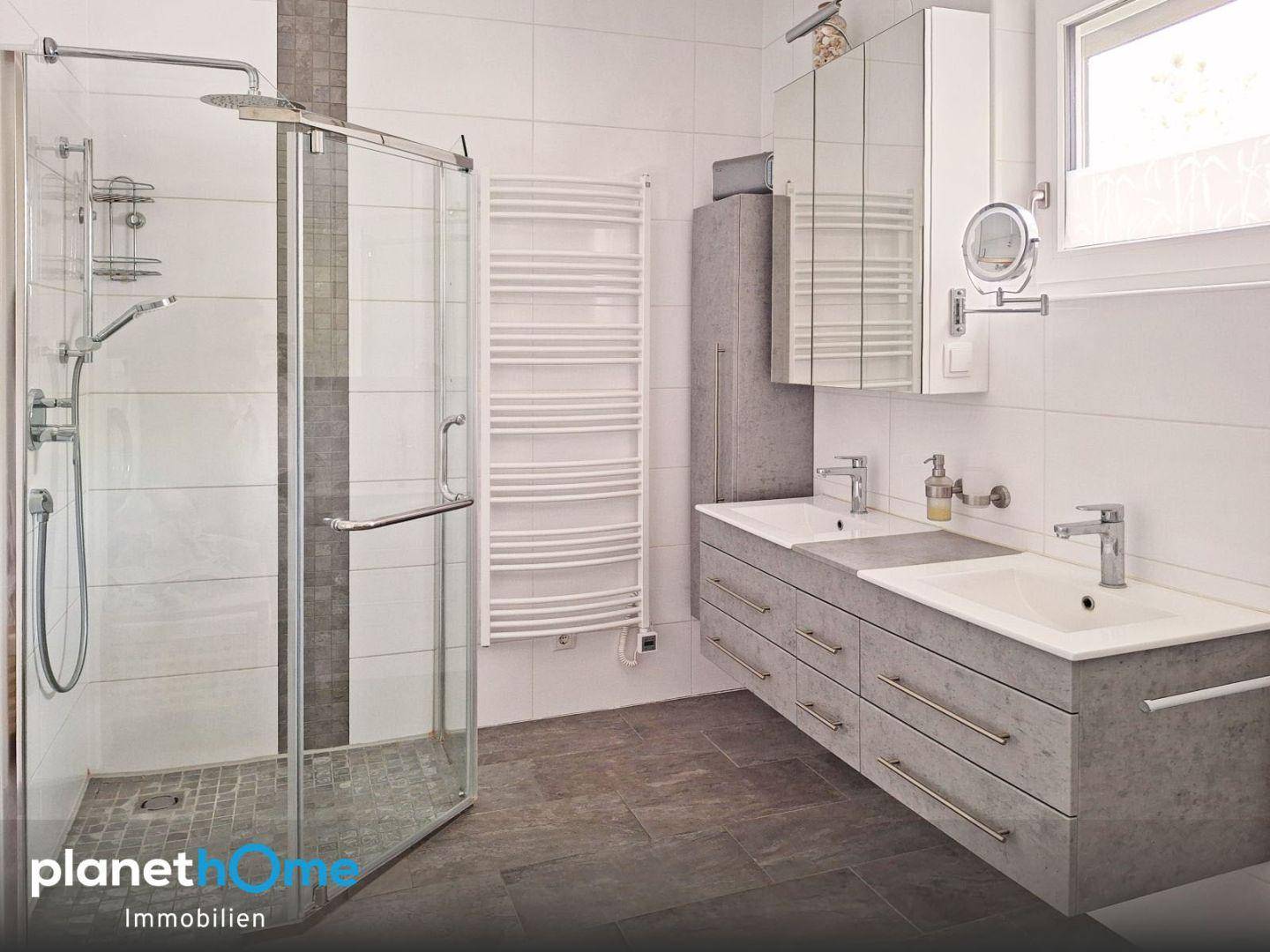 Modernes Badezimmer mit großer begehbarer Dusche, Doppelwaschbecken und Handtuchheizkörper.