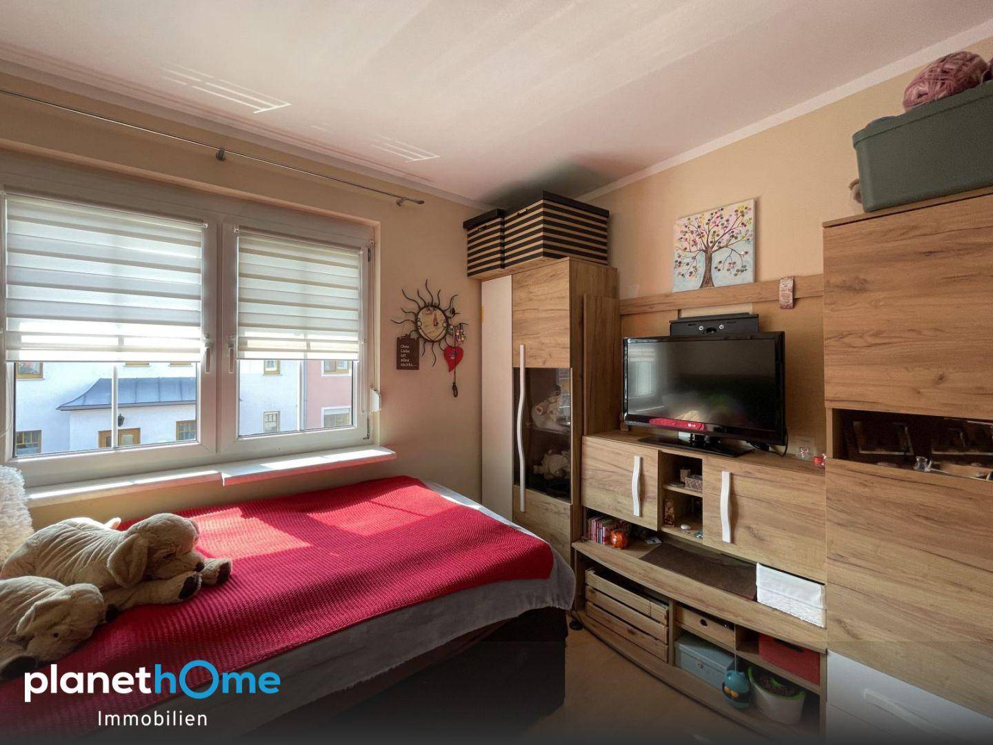 Kinderzimmer oder Gästezimmer mit Einzelbett, Kleiderschrank und Fenster, gemütlich eingerichtet.