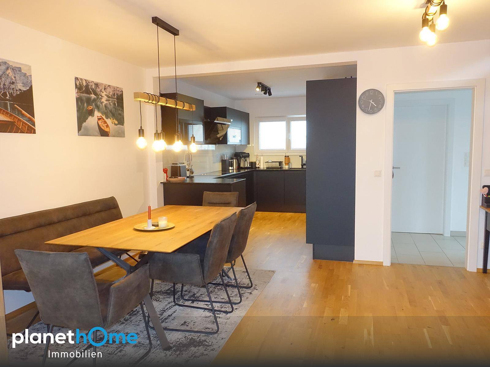 Gemütlicher Essbereich mit Holztisch und Sitzbank, angrenzend an eine moderne Küche.