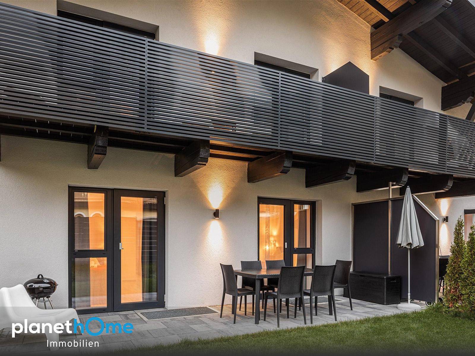 Attraktive Terrasse mit Esstisch und Stühlen, ideal für Mahlzeiten im Freien, unter einem modernen Balkon.