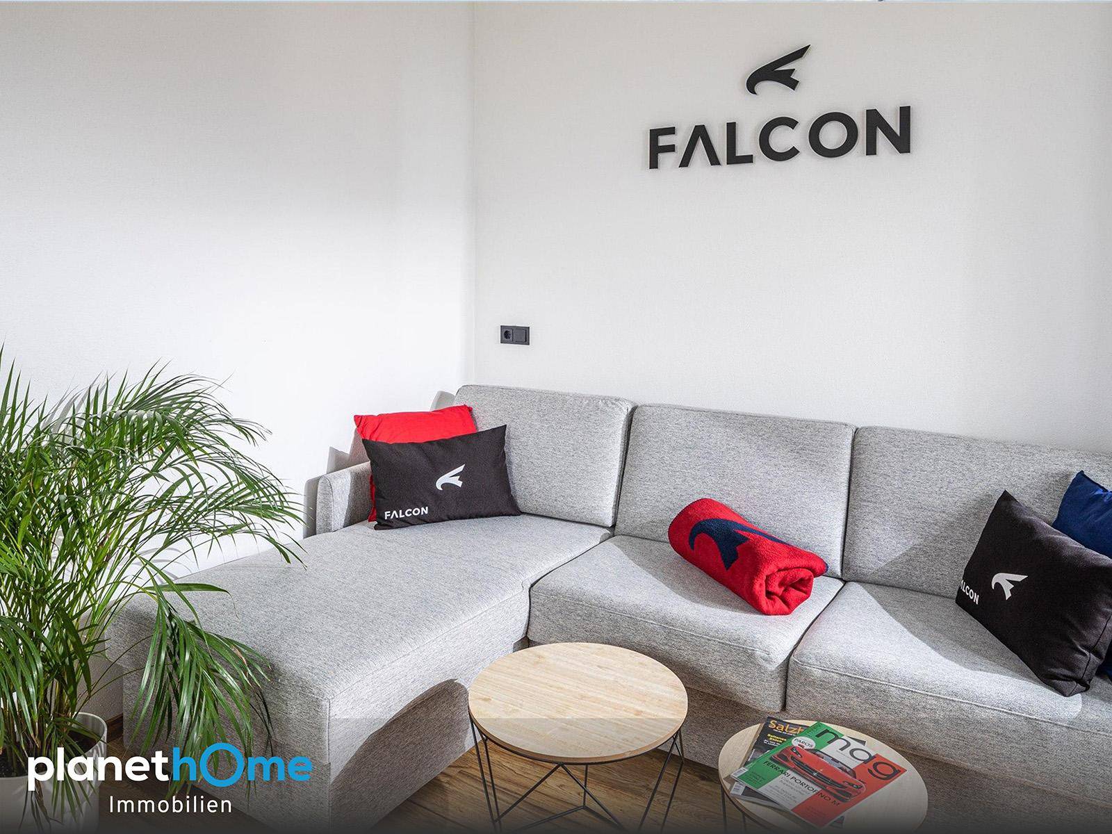 Gemütliche Wohnzimmerecke mit grauem Ecksofa, Zierpflanze und Couchtischen, modern und hell.