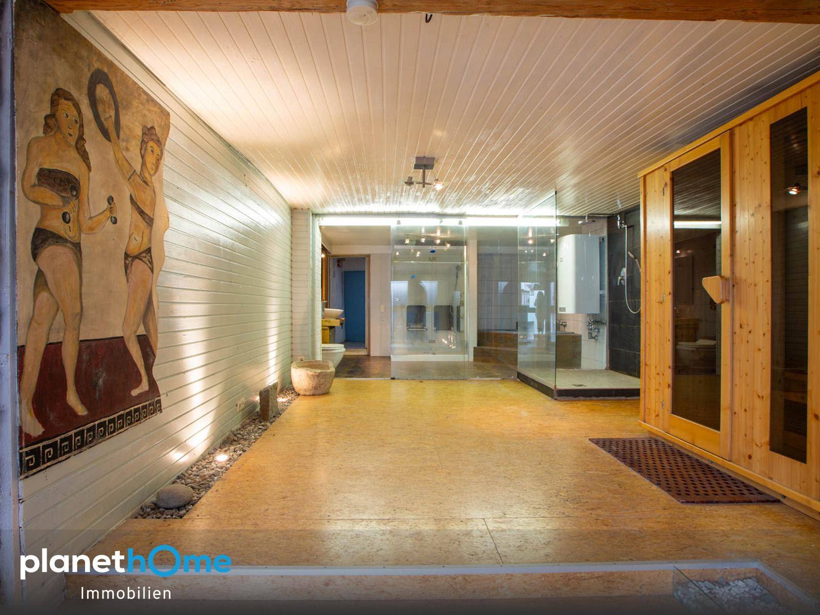 Geräumiger Wellnessbereich mit Sauna, Wandmalerei und entspannender Atmosphäre.