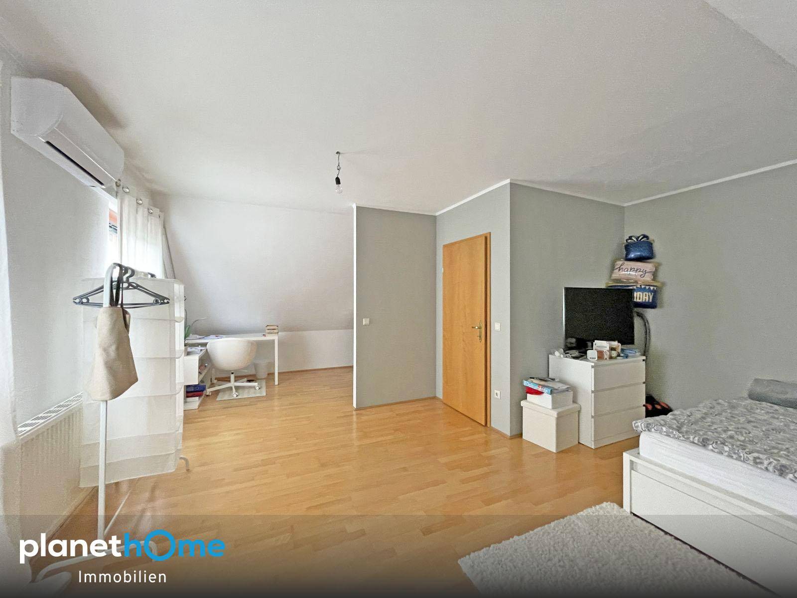 Helles Dachgeschosszimmer mit Holzboden, Klimaanlage und viel Platz.