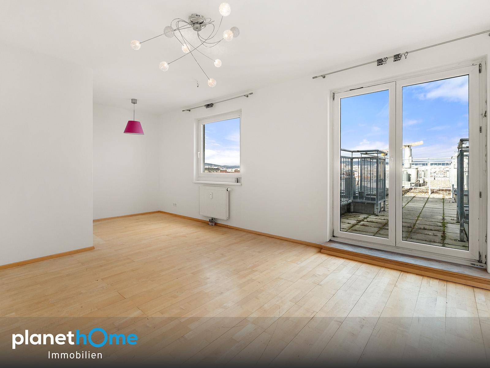 Heller Raum mit Holzboden, Fenster und großem Terrassenzugang, ideal für vielseitige Nutzung.