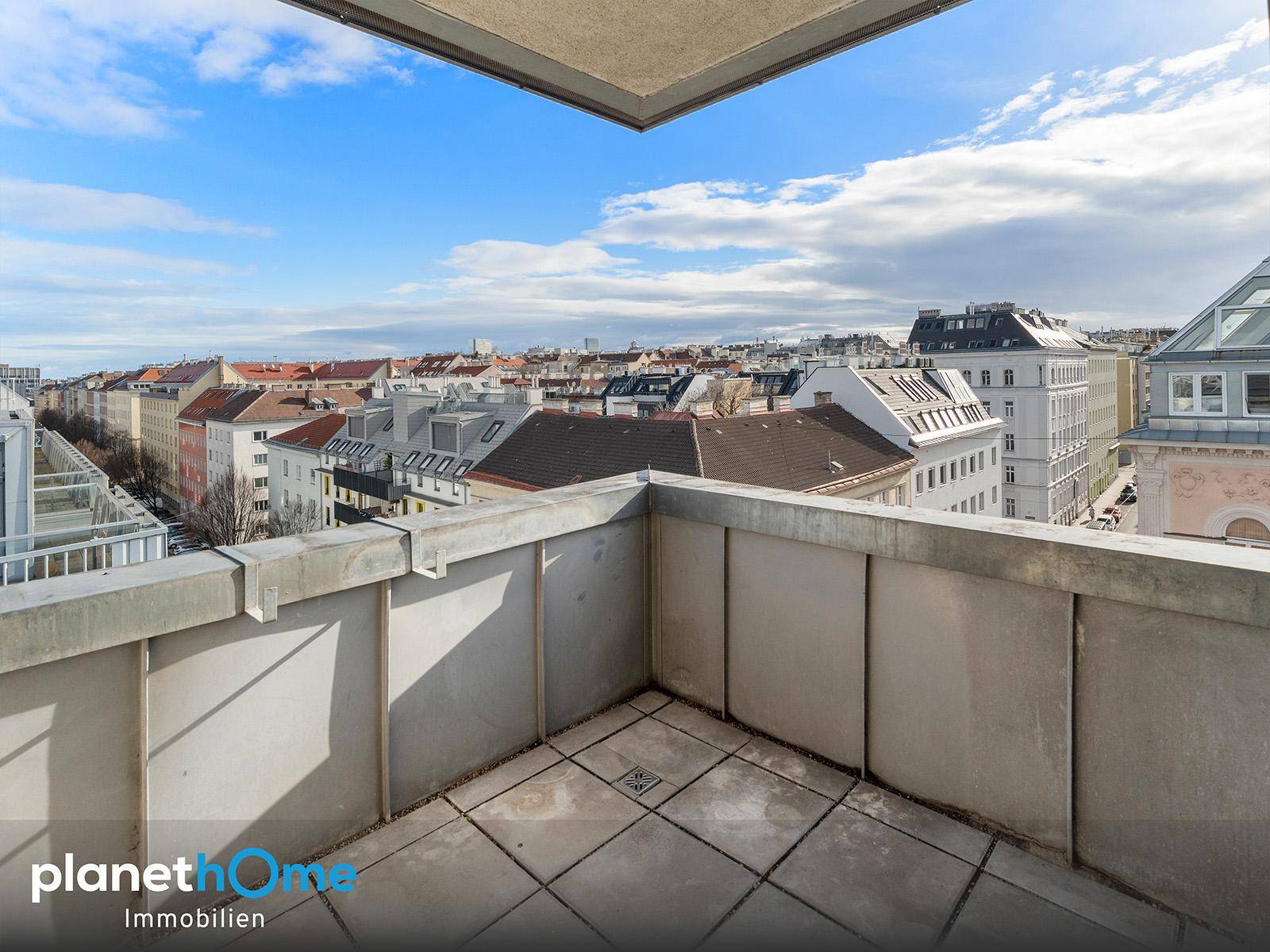 Geräumiger Balkon mit Fliesenboden und weitem Blick über die Stadt.