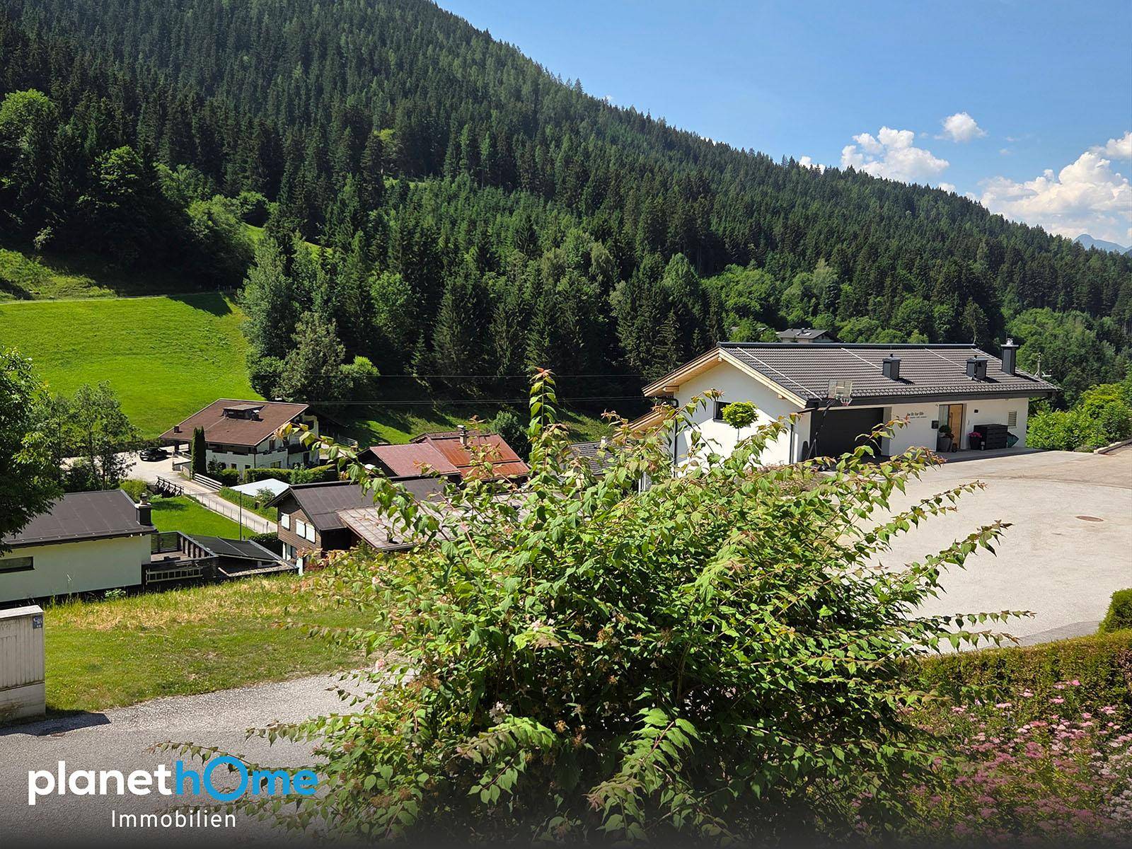 Panoramablick auf die umliegende Berglandschaft und benachbarte Häuser.