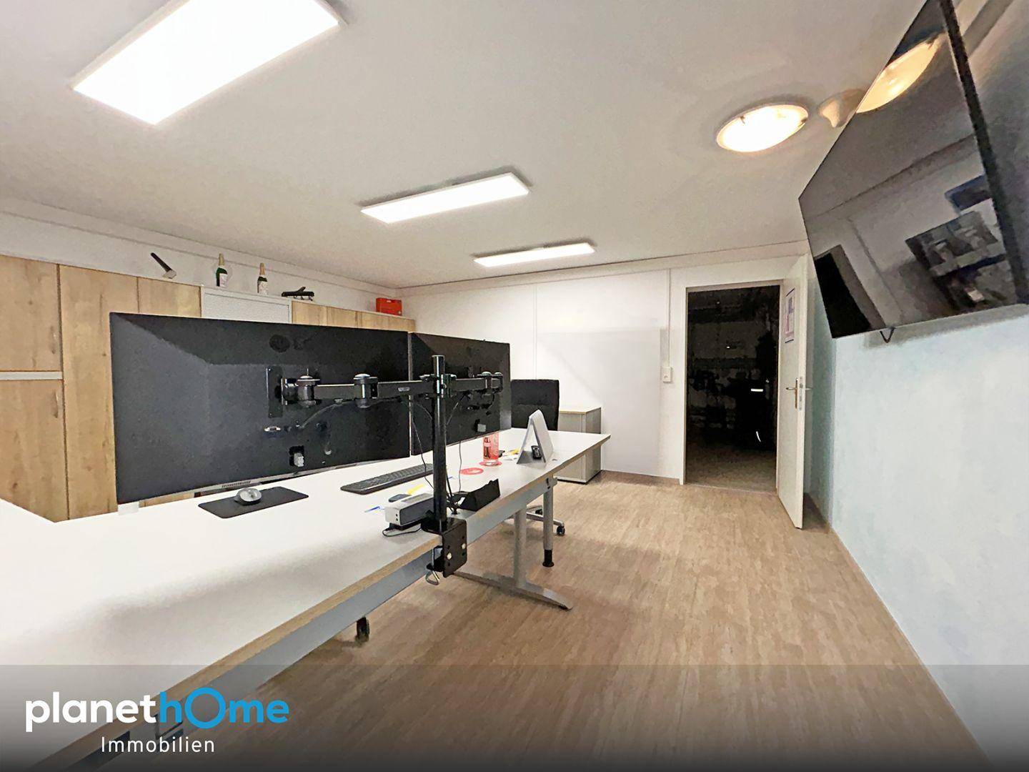 Modernes Büro mit mehreren großen Bildschirmen und viel Arbeitsfläche für produktives Arbeiten.