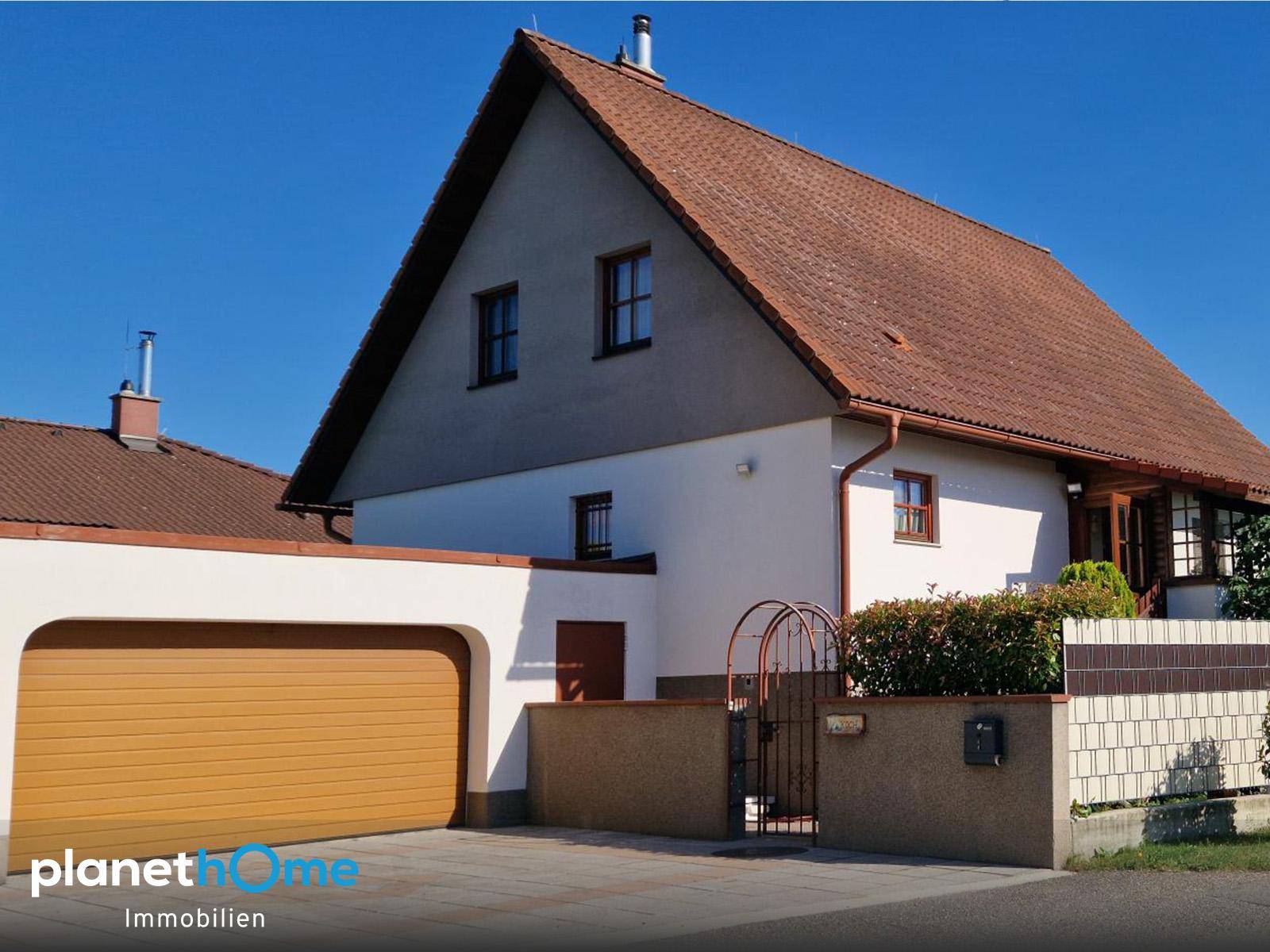 Vorderansicht des Einfamilienhauses mit Satteldach und integrierter Garage.
