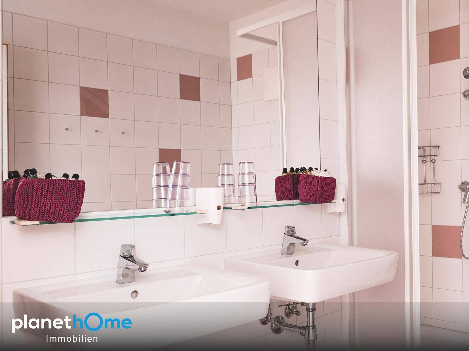 Modernes Badezimmer mit zwei Waschbecken, großen Spiegeln und einer Duschkabine.