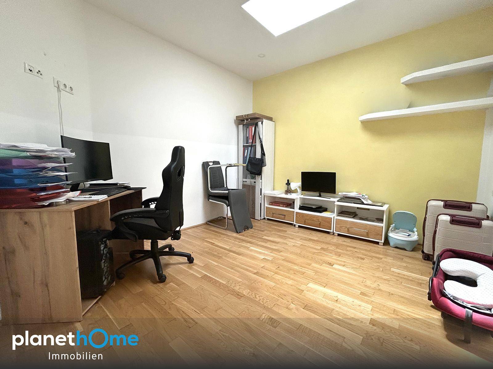 Helles Arbeitszimmer mit Schreibtisch, Bürostuhl und gelber Akzentwand, ausgestattet mit einem Dachfenster.