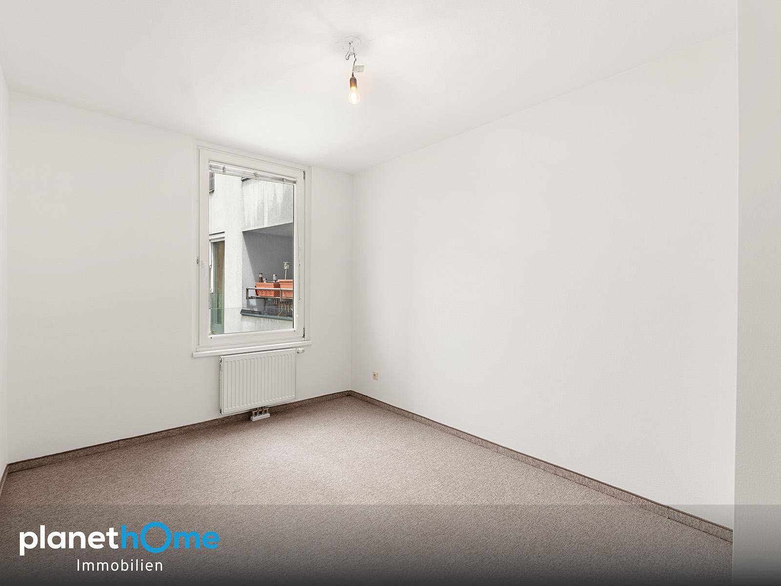Ruhiges Schlafzimmer mit Teppichboden und Blick auf einen kleinen Außenbereich.