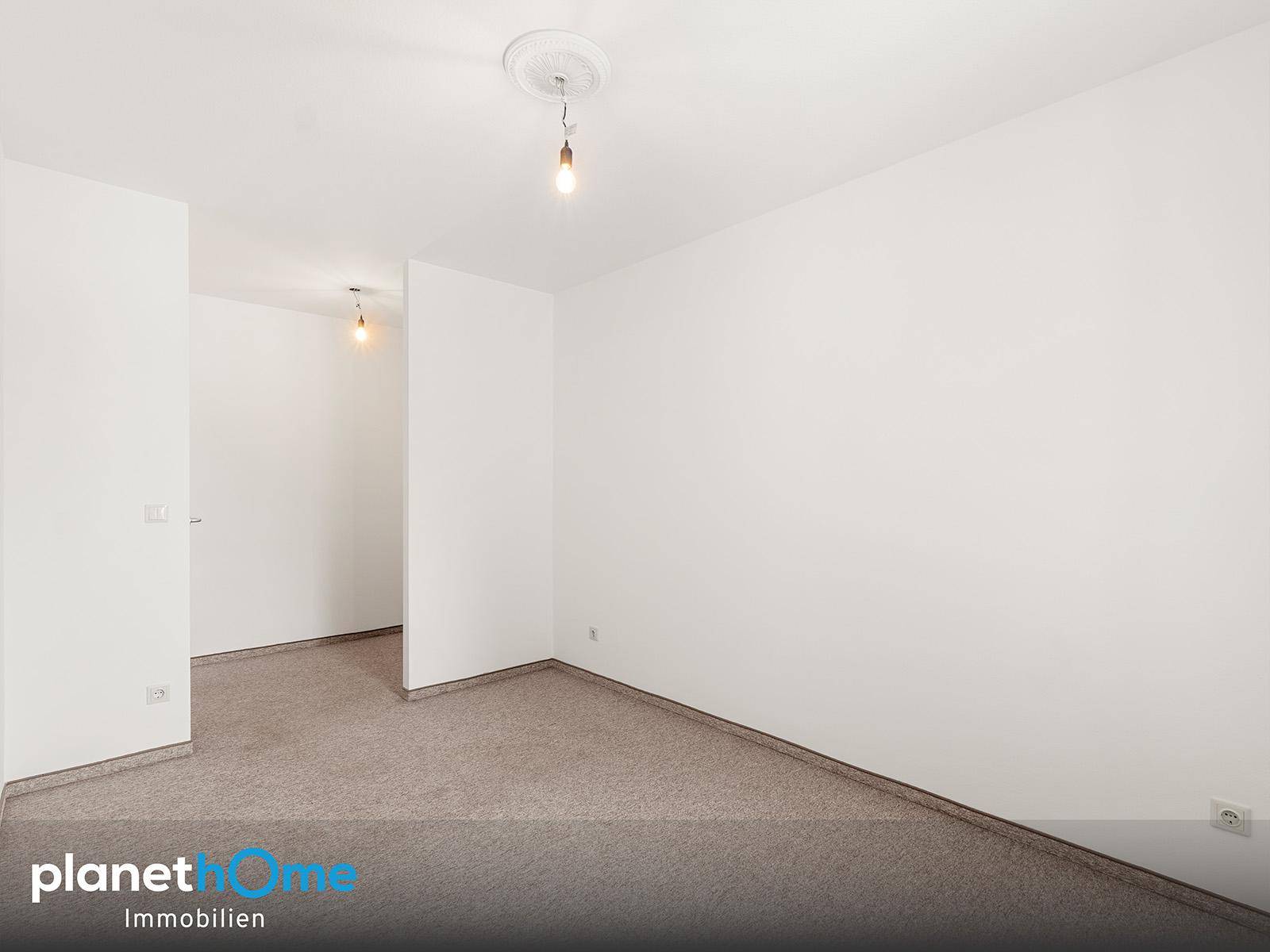 Leeres Zimmer mit Teppichboden, bereit zur individuellen Gestaltung.