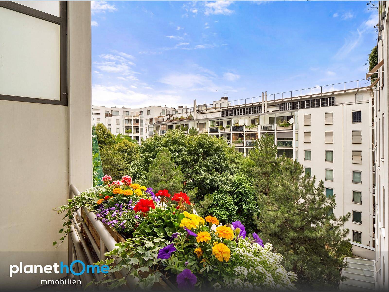 Sonniger Balkon mit üppigen Blumen und Bäumen, bietet einen angenehmen Ausblick.
