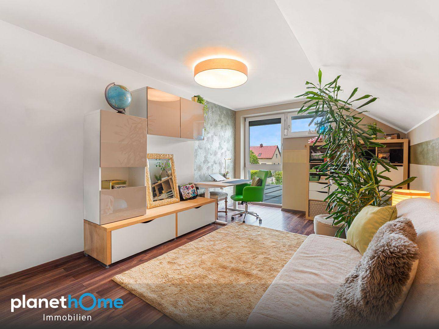 Helles Schlafzimmer mit Dachschräge, Arbeitsbereich und Blick ins Grüne.