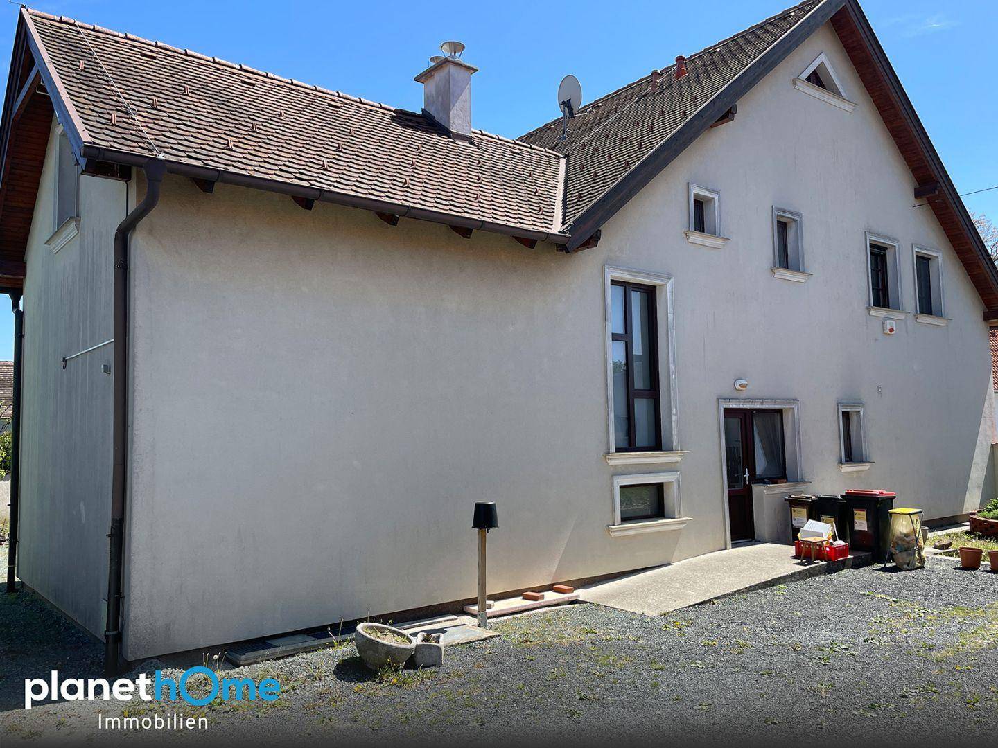 Seitenansicht des Hauses mit Rampe zum Eingang und hellem Putzfassade.