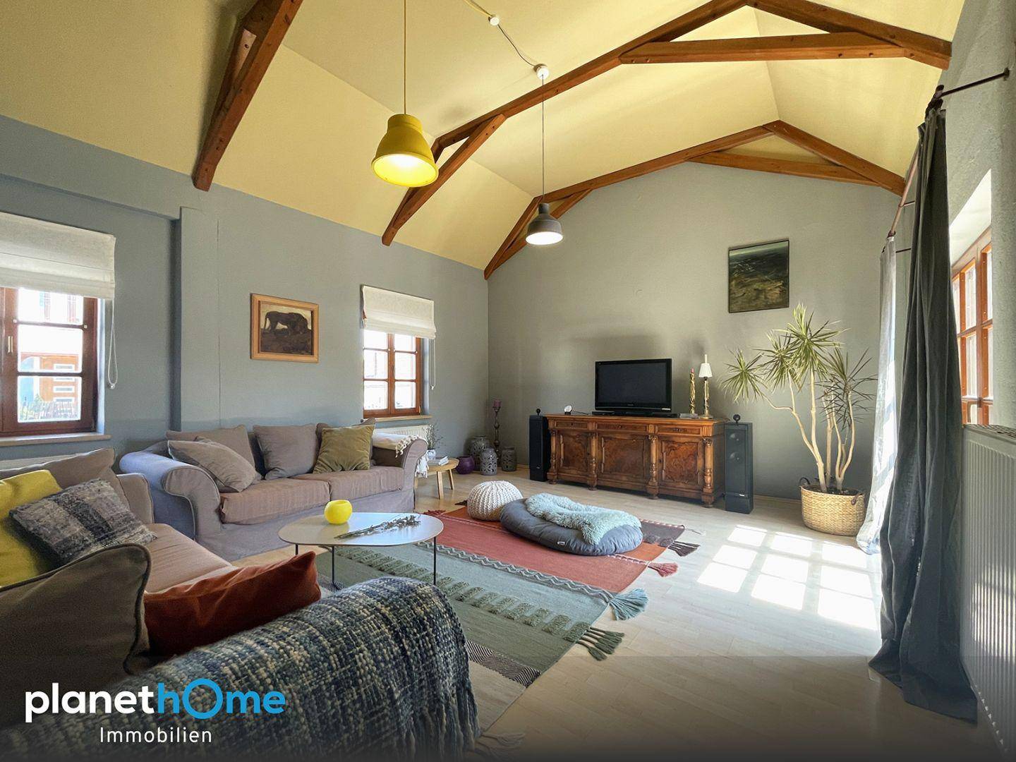Geräumiges Wohnzimmer mit gemütlicher Sitzecke, Holzbalkendecke und rustikalen Möbeln.