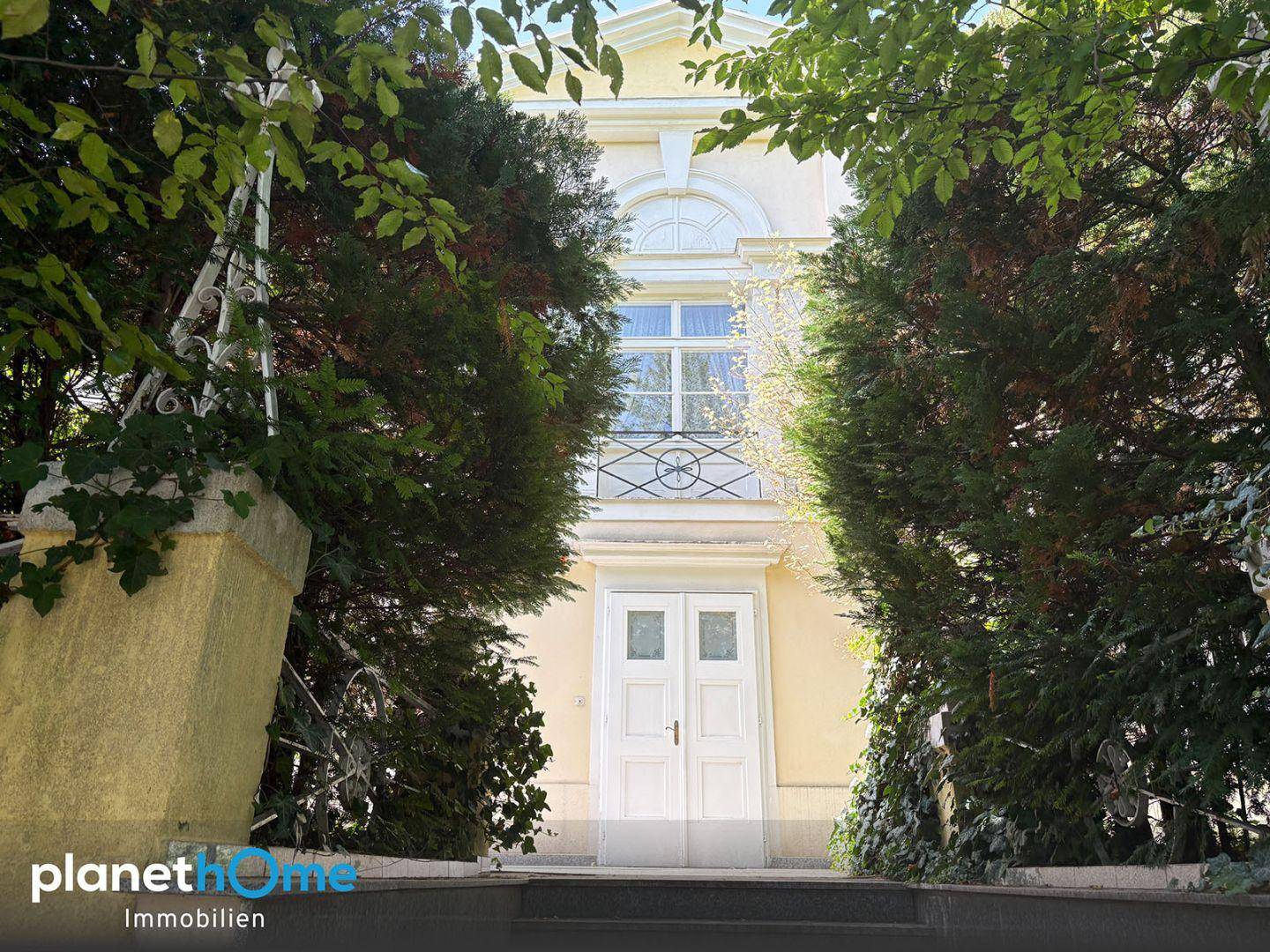 Hauptfassade der Villa mit elegantem Eingangsbereich und französischem Balkon.
