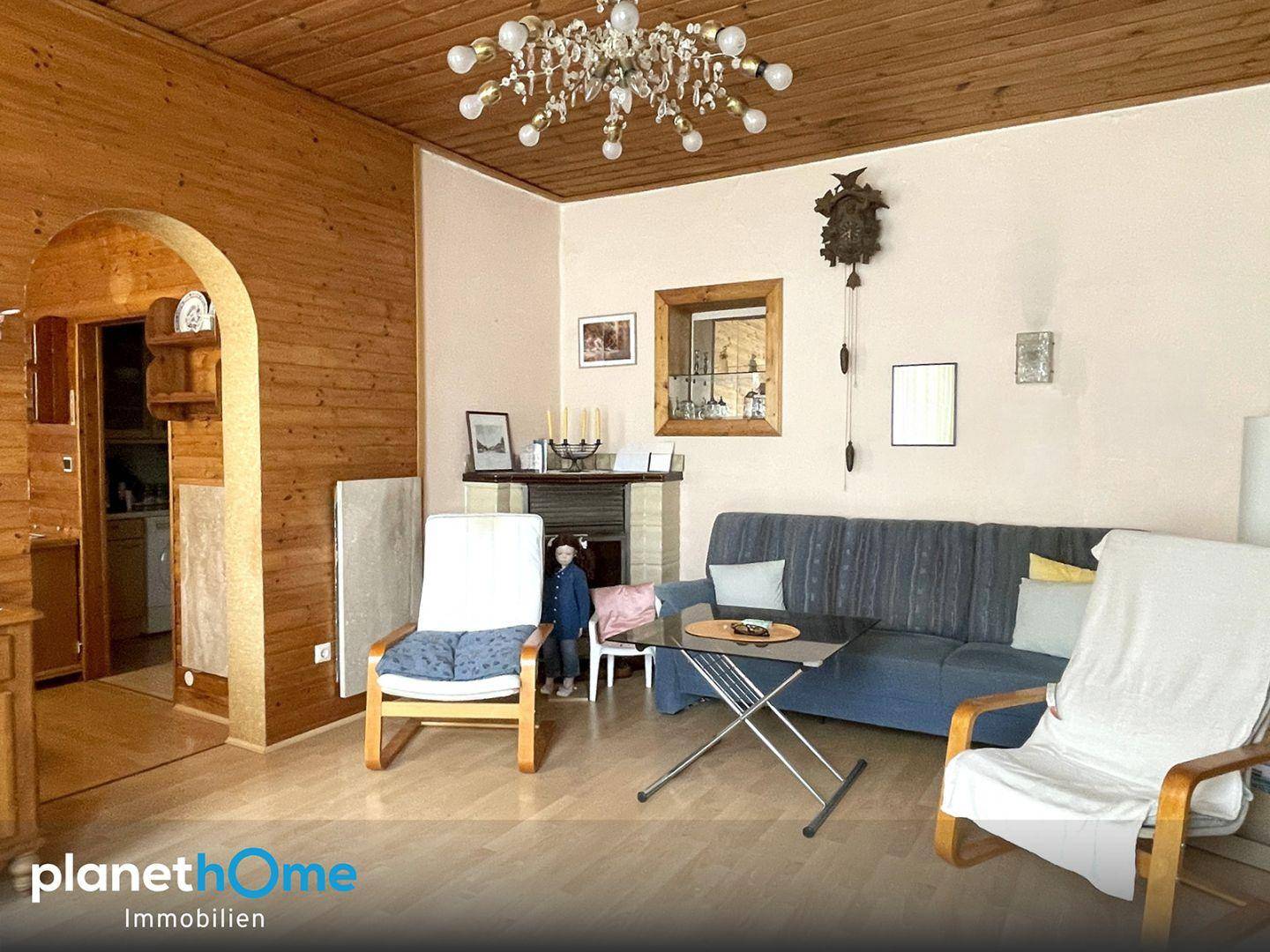 Gemütliches Wohnzimmer mit Holzvertäfelung, Parkettboden und traditioneller Einrichtung mit Kamin.