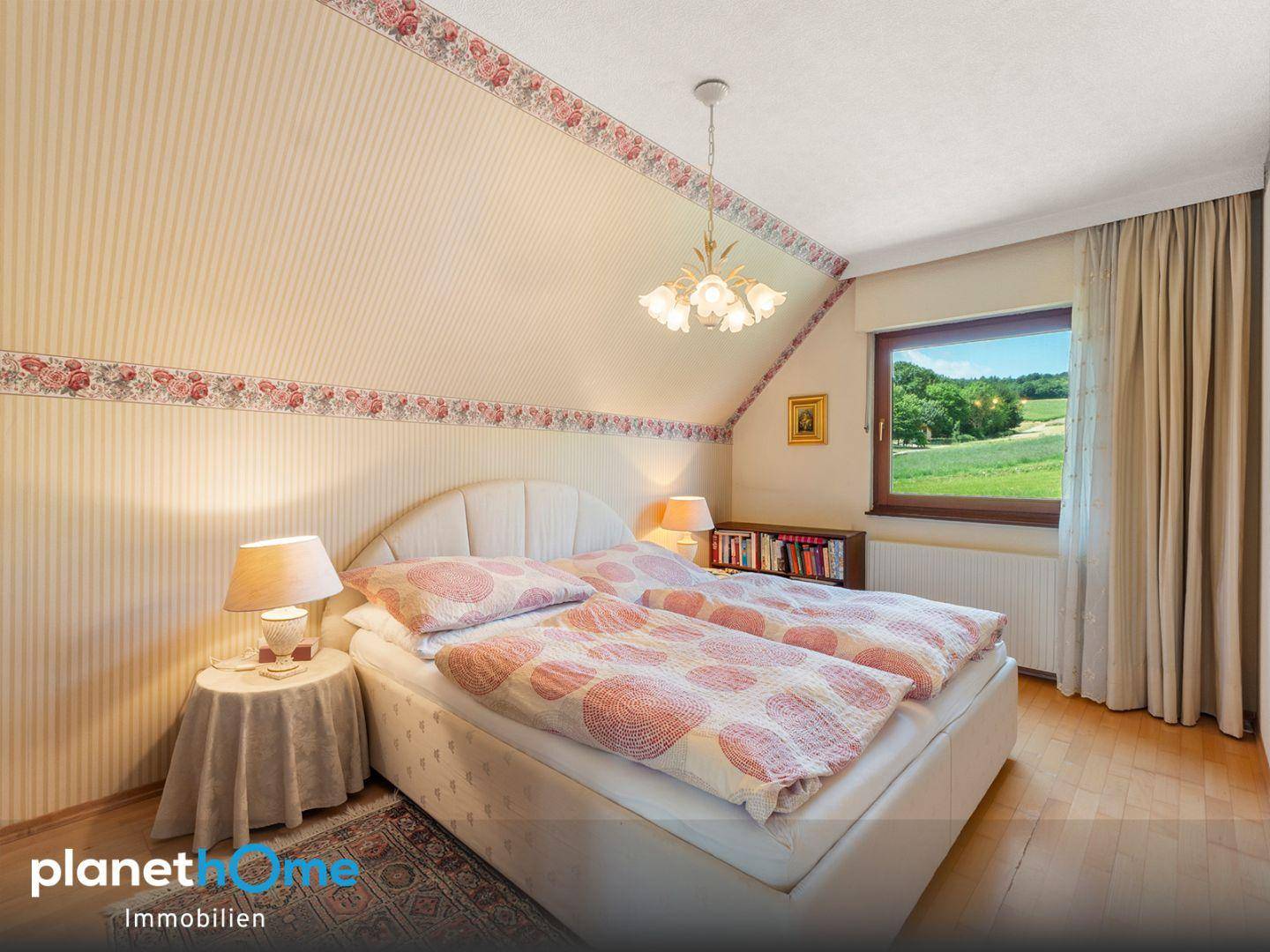 Gemütliches Schlafzimmer mit Doppelbett, gemusterter Tapete und Blick auf die umliegende Landschaft.