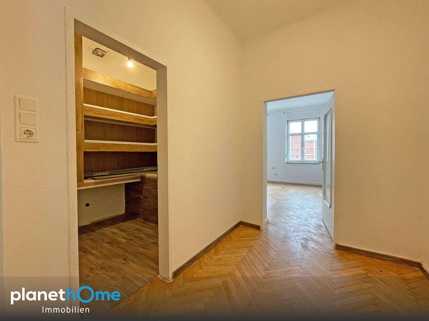 Heller Flur mit integriertem Abstellraum und Zugang zu einem weiteren Zimmer.