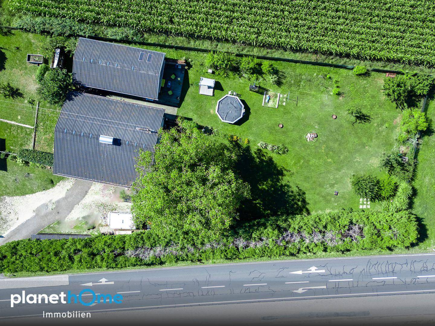 Detaillierte Luftaufnahme des Hauses mit Garten, Pool und angrenzender Hecke.