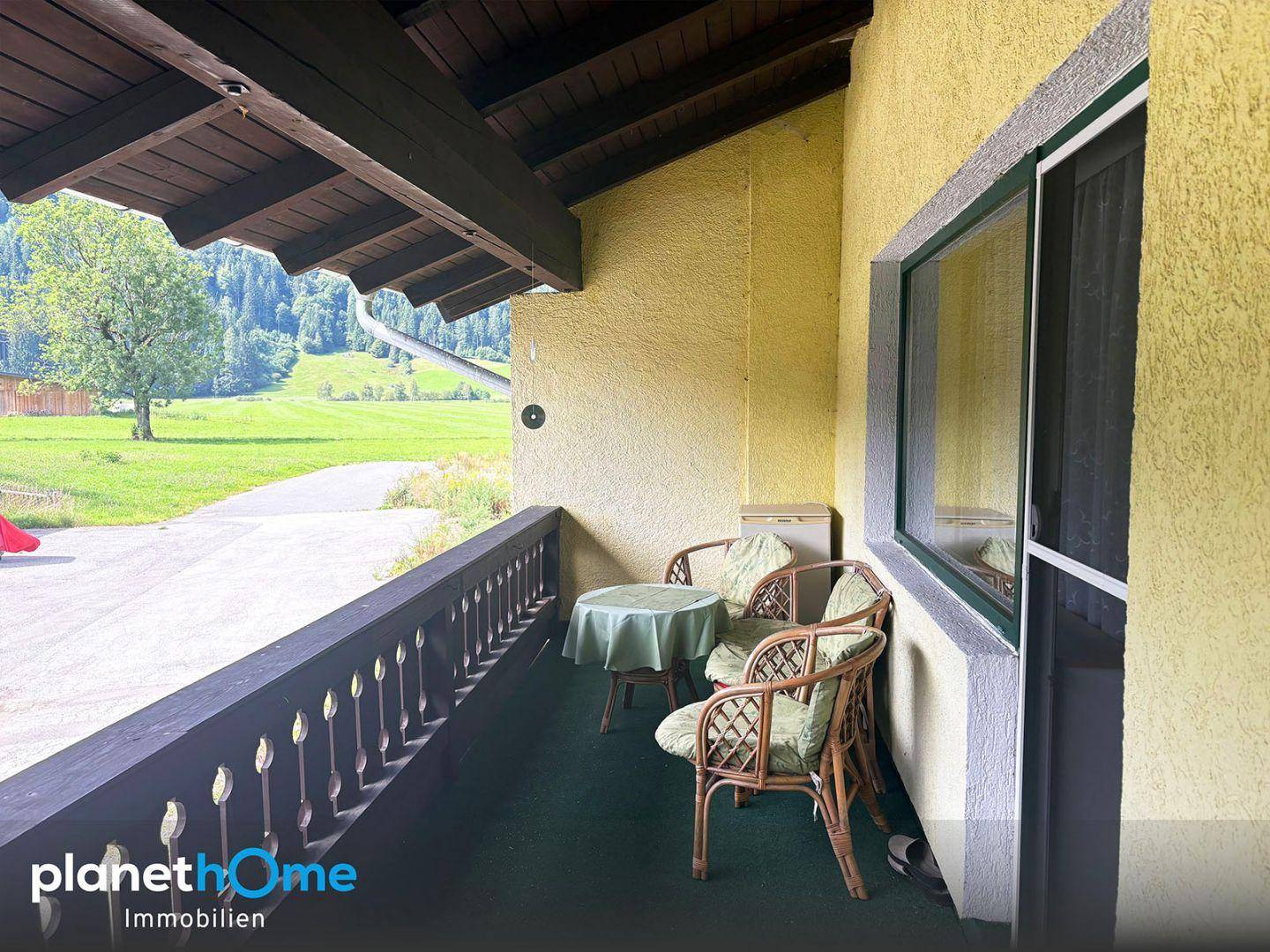 Gemütlicher Balkon mit Sitzgelegenheiten und weitem Blick auf die grüne Landschaft.