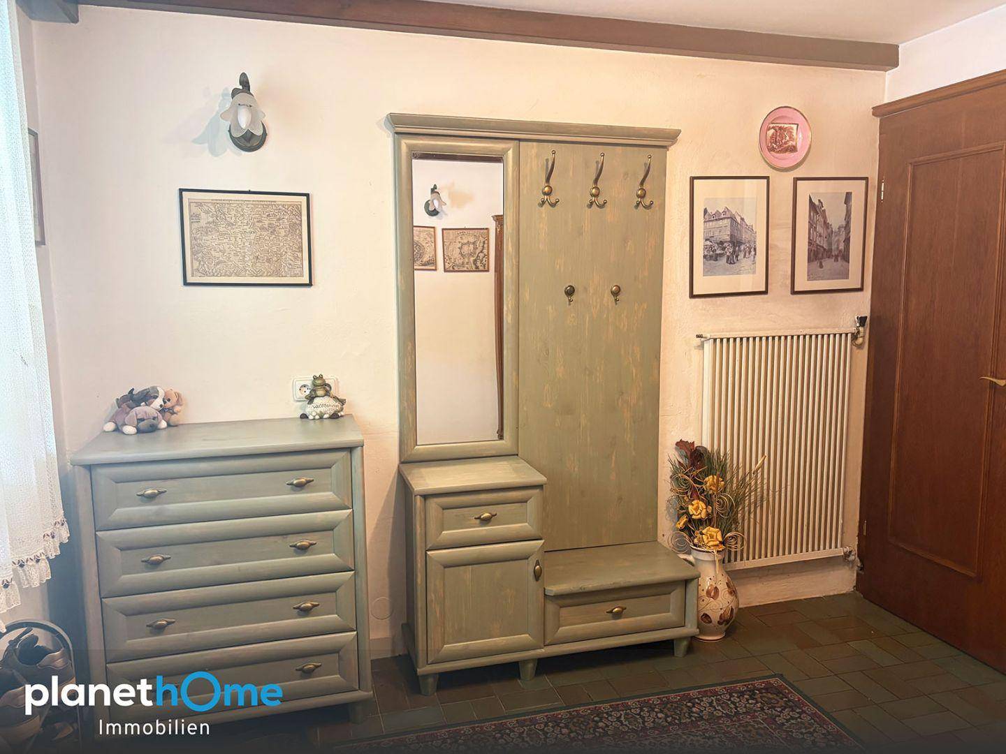 Eingangsbereich mit Garderobe, Spiegel und Kommode in traditionellem Stil.