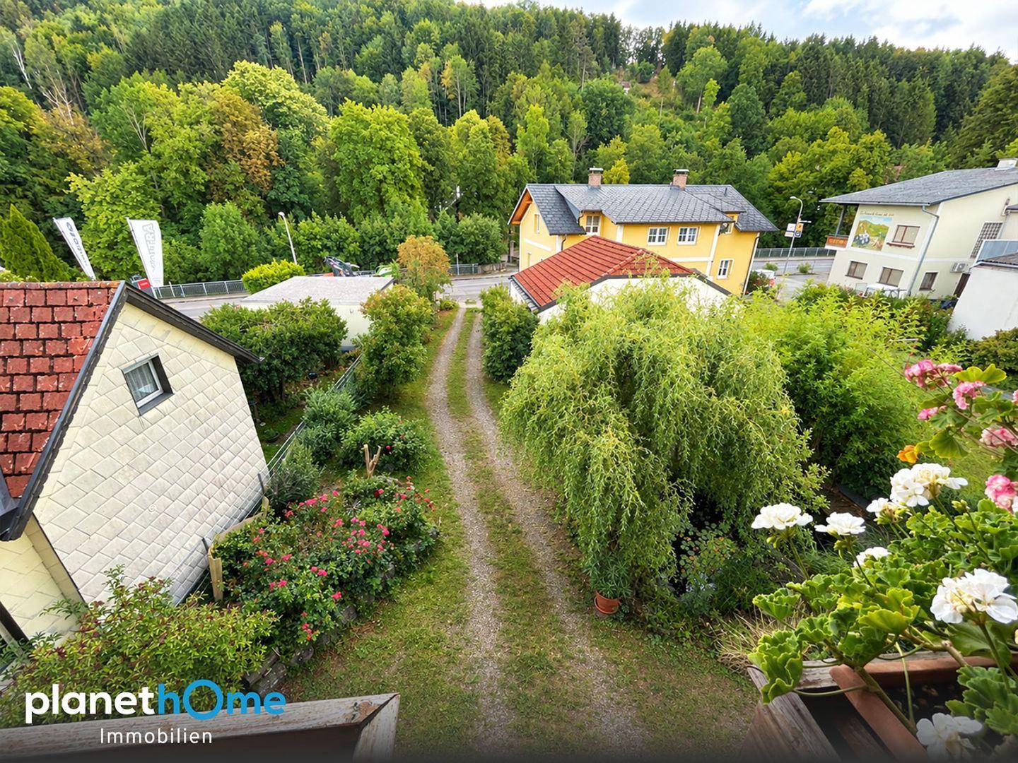 Panoramablick auf das Anwesen und die umliegende grüne Hügellandschaft mit weiteren Häusern.