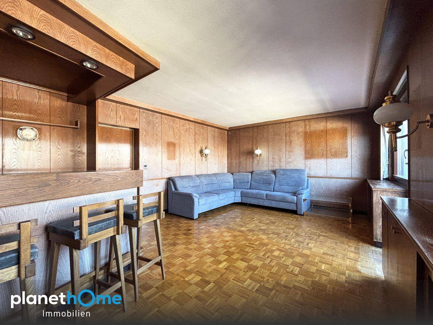 Wohnzimmer im traditionellen Stil mit Holzvertäfelung, Parkettboden und Vintage-Möbeln.