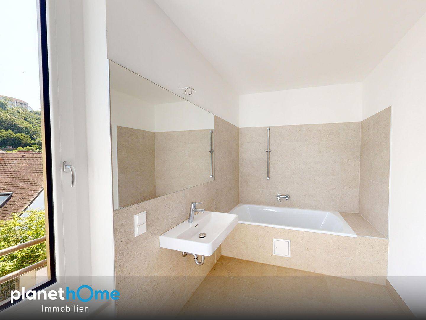 Modernes Badezimmer mit Badewanne, Einzelwaschbecken und großem Spiegel.