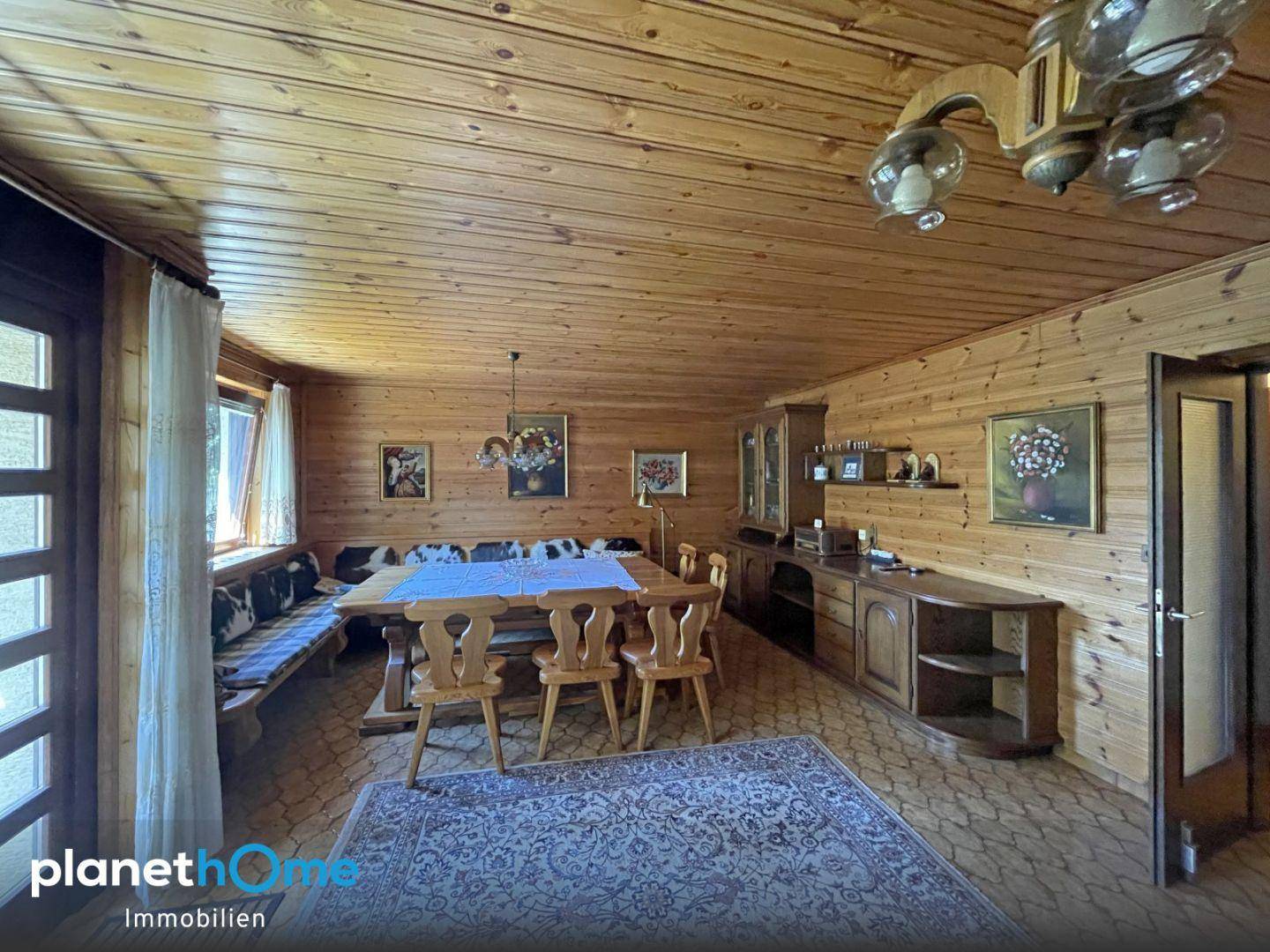 Traditioneller Essbereich mit Holzvertäfelung, Holztisch und Sitzbank im alpinen Stil.