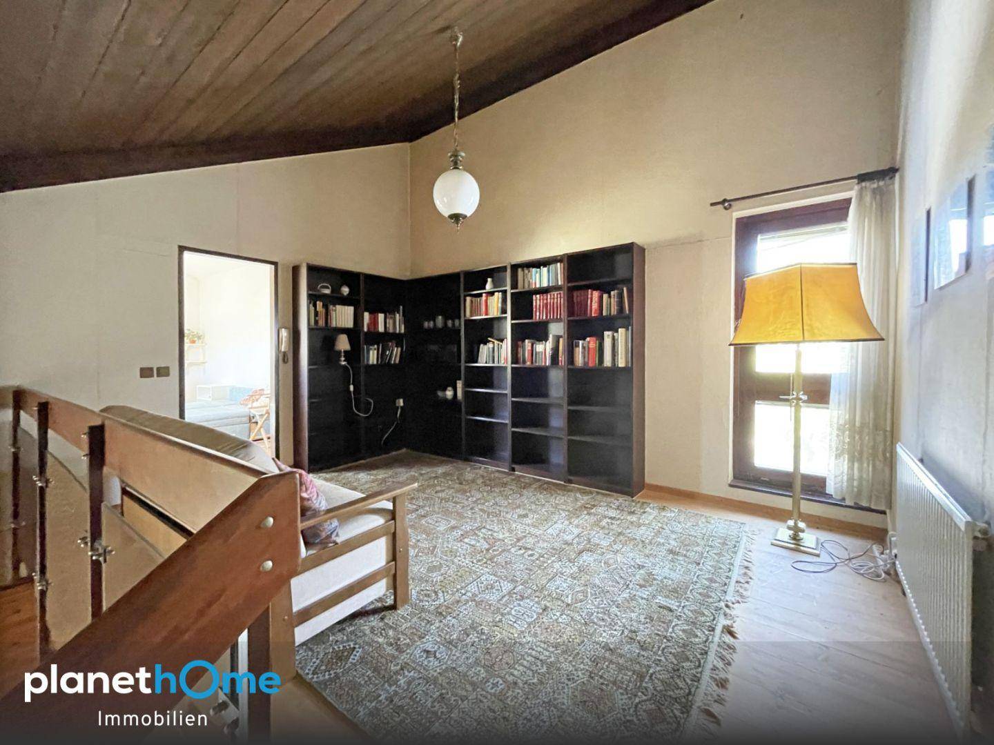 Offene Galerie mit Bücherregalen und Blick auf den unteren Wohnbereich, ideal als Bibliothek.