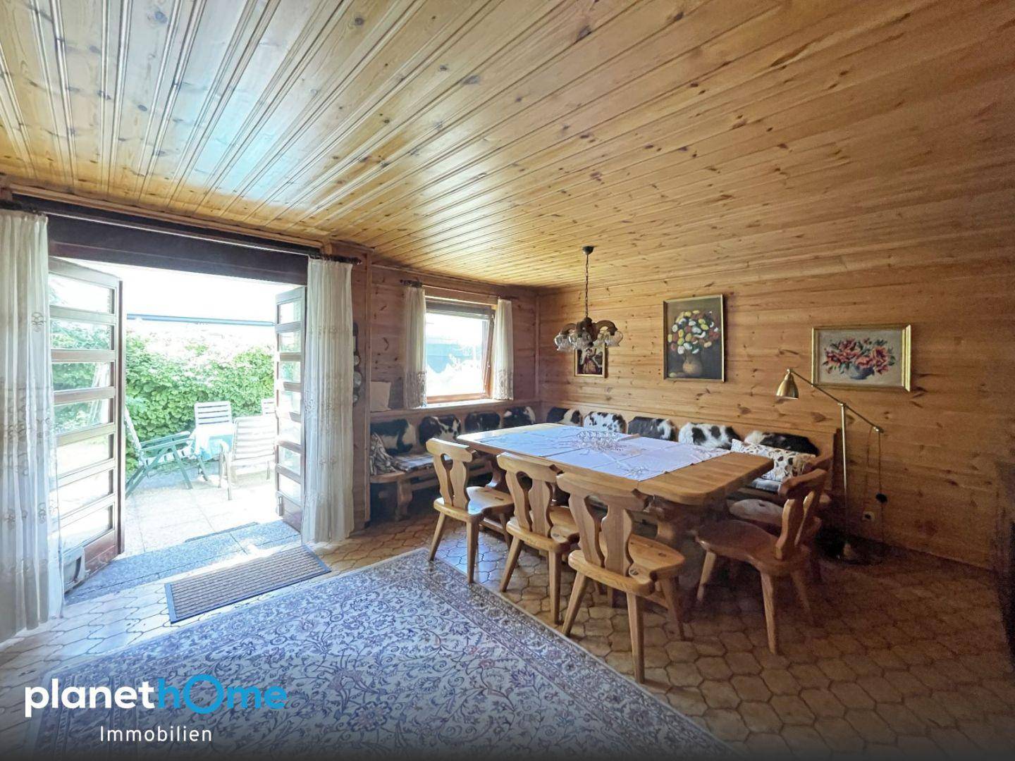 Heller Essbereich mit Holzwänden und direktem Zugang zur Außenterrasse für Mahlzeiten im Freien.