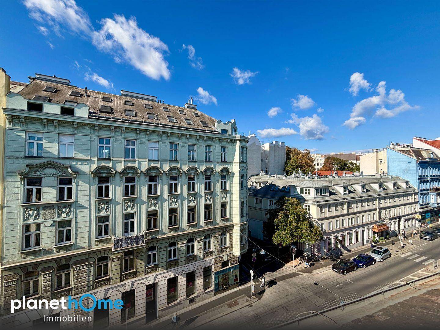 Historische Stadtansicht mit charmanten Altbauten, einer belebten Straße und blauem Himmel.