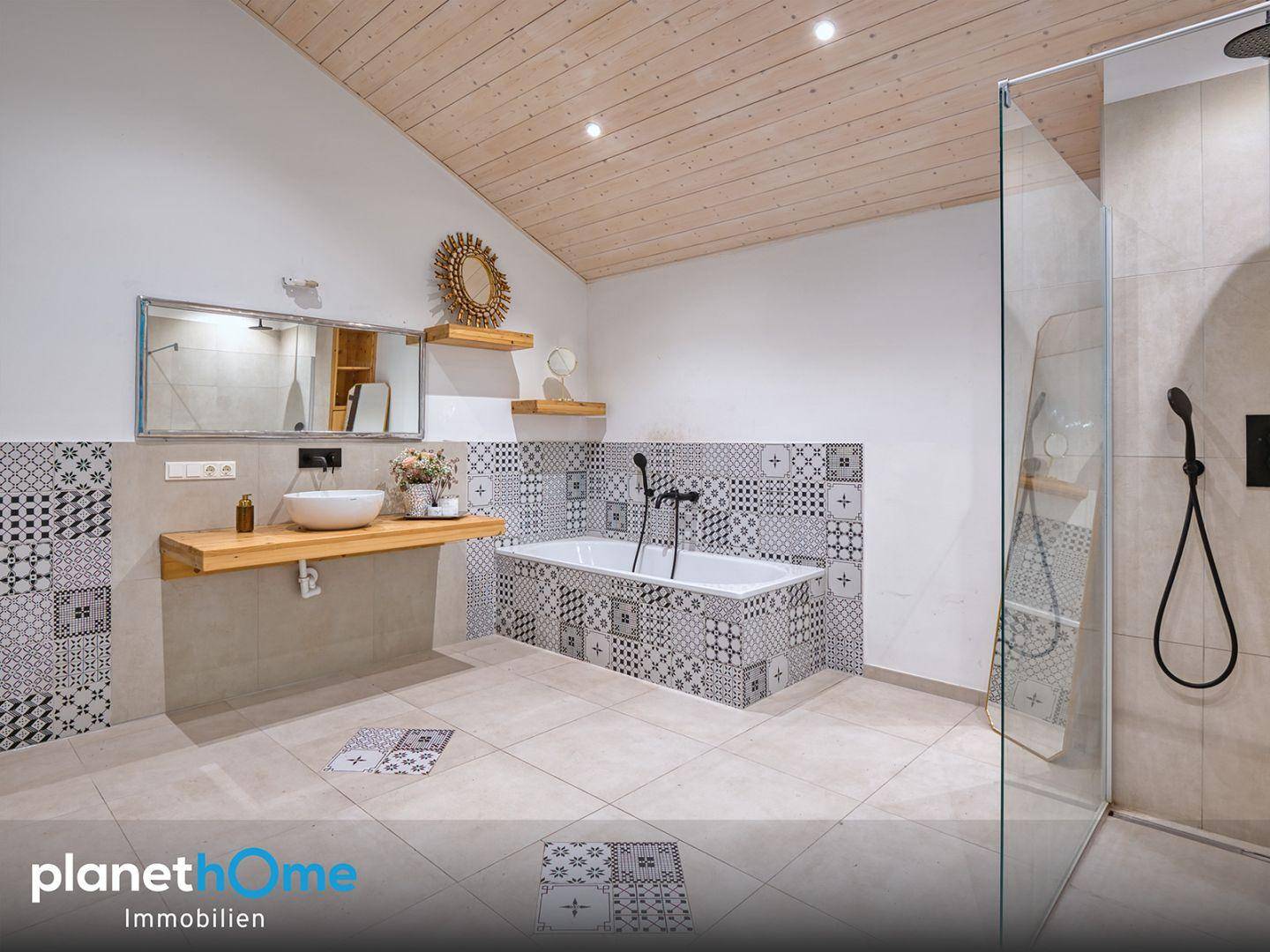 Modernes Badezimmer mit Badewanne, begehbarer Dusche und gemusterten Fliesen, Dachschräge.