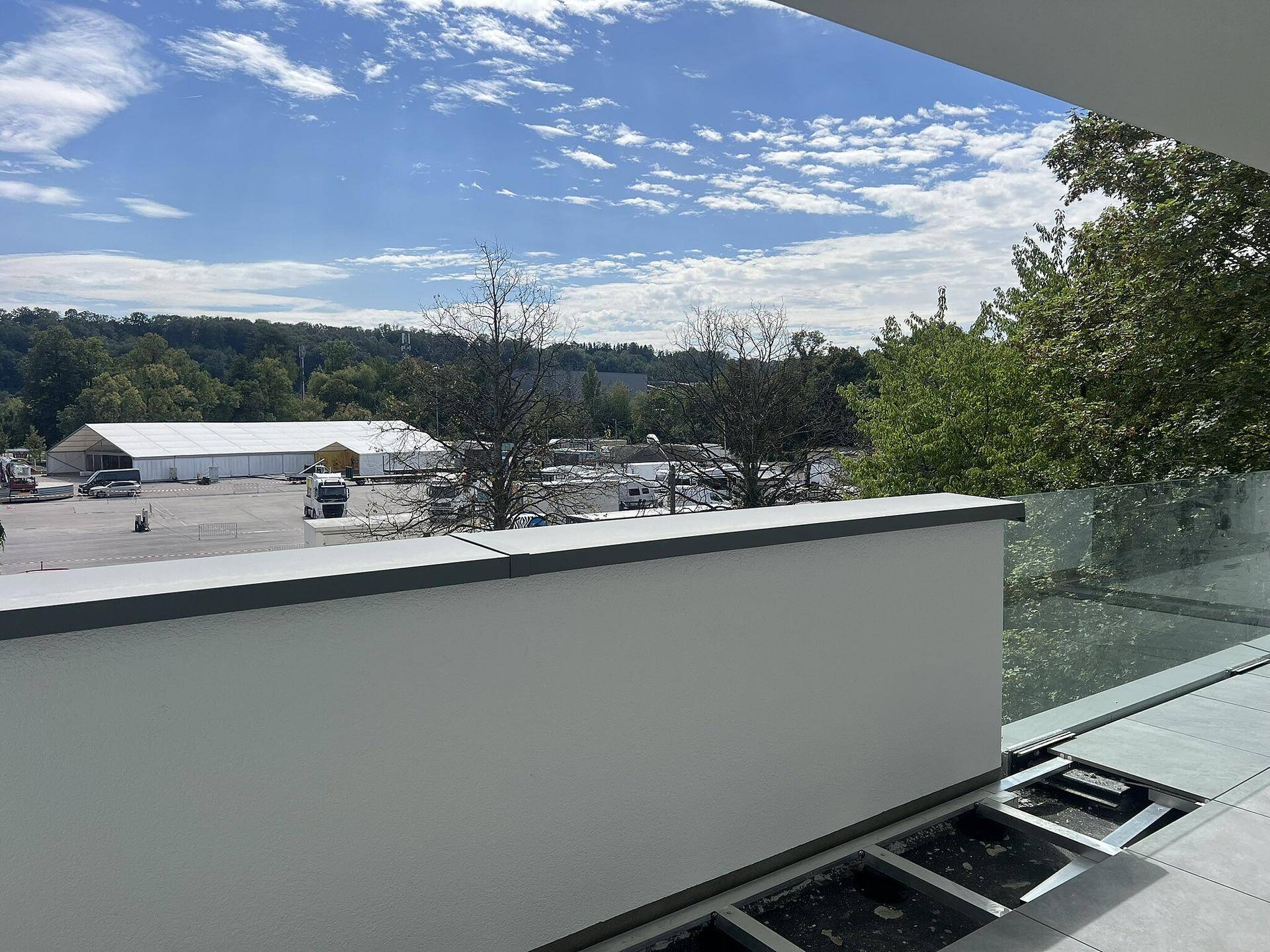 Balkon mit weitem Blick über die Landschaft und angrenzende Gewerbeflächen.