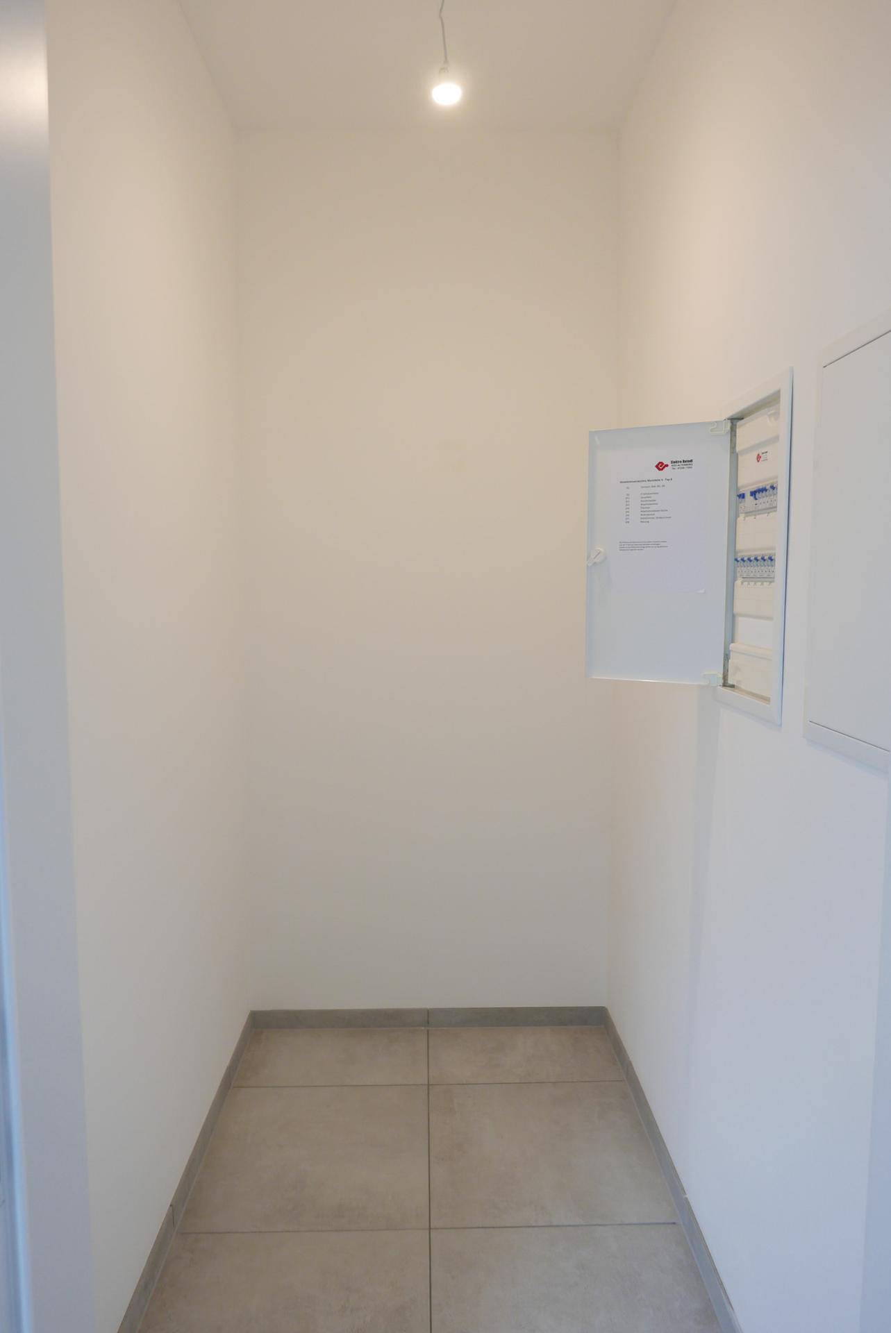 Kleiner Abstellraum mit Sicherungskasten und Fliesenboden, ideal für zusätzlichen Stauraum.