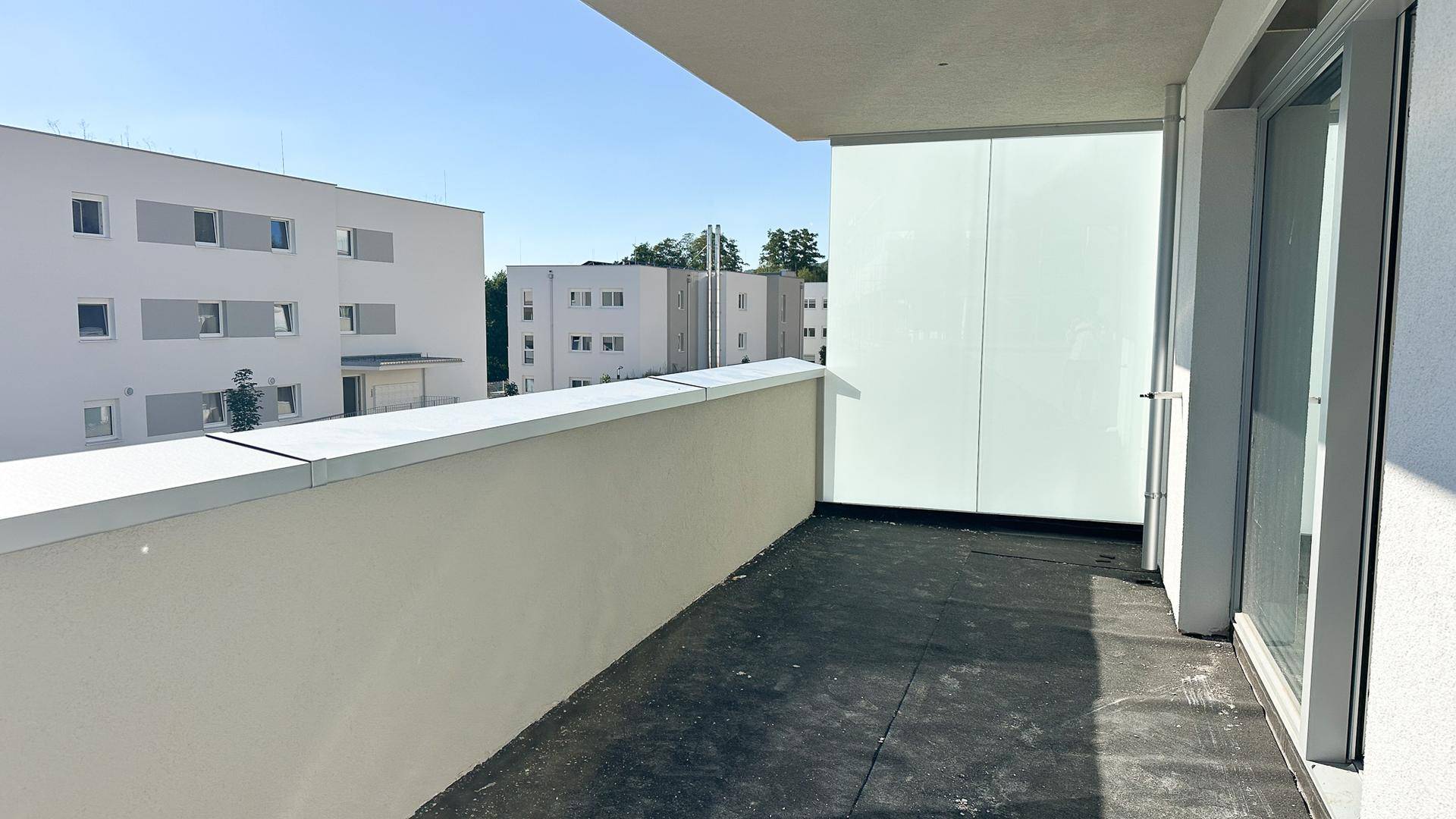 Geräumiger Balkon im Bau mit Blick auf die umliegenden modernen Wohngebäude.