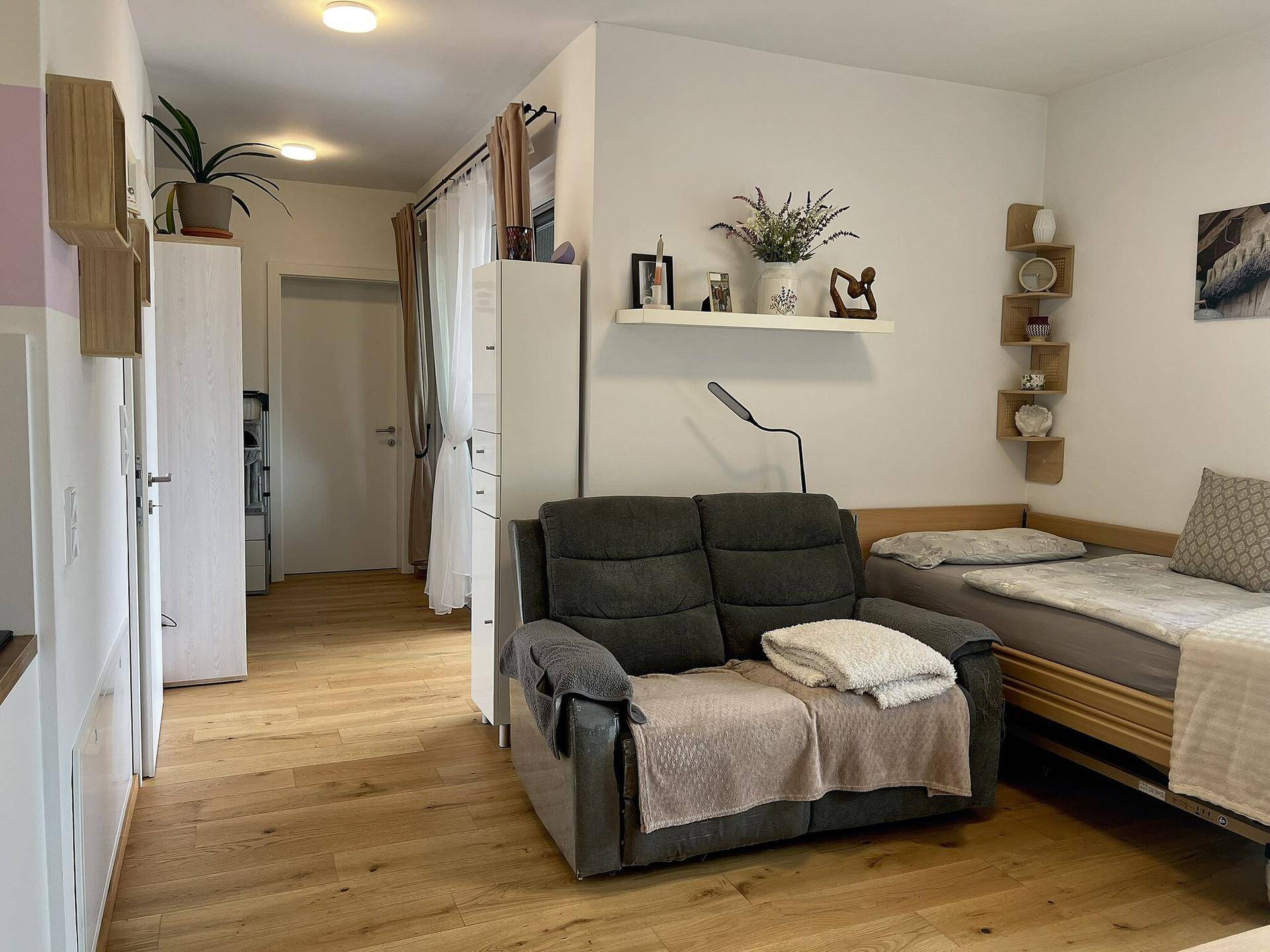 Gemütlicher Wohnbereich mit Sofa, Tagesbett und modernen Dekorationselementen, ideal zum Entspannen.