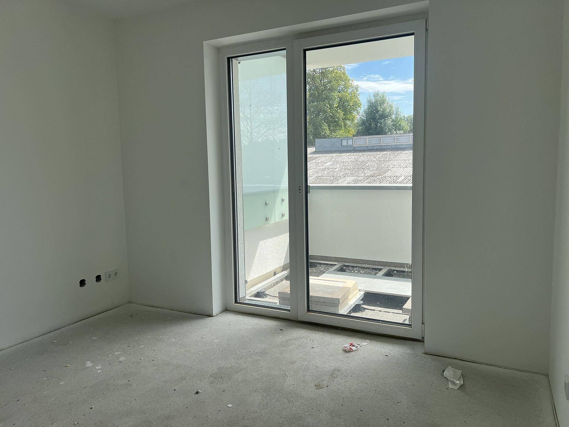 Heller Raum mit Schiebetür zum Balkon, bietet viel Tageslicht und eine offene Atmosphäre.