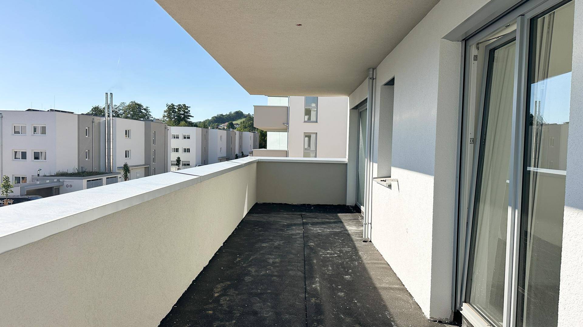 Langer Balkon im Bau mit Blick auf die moderne Architektur der Nachbargebäude.