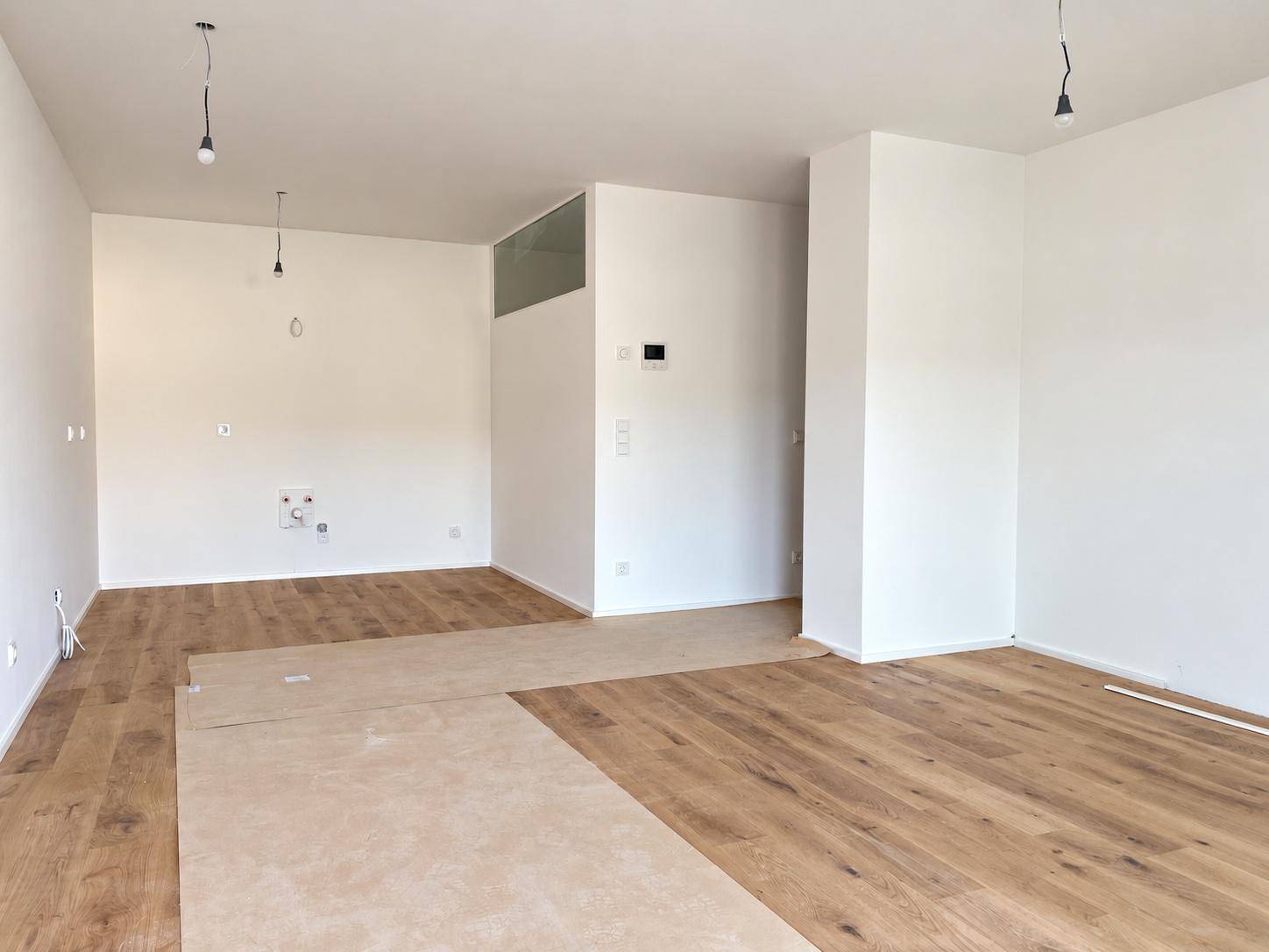 Großzügiger, heller Wohnbereich mit neuem Holzboden und offener Raumgestaltung.