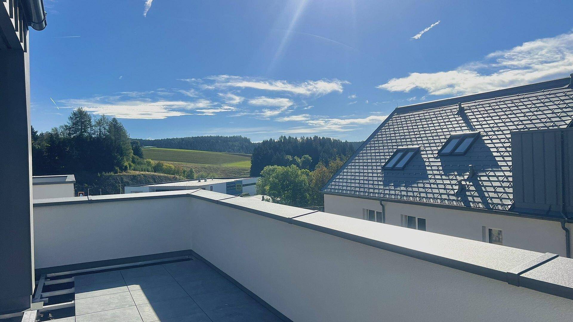 Weitläufige Dachterrasse mit Panoramablick über die umliegende Landschaft und Hügel.