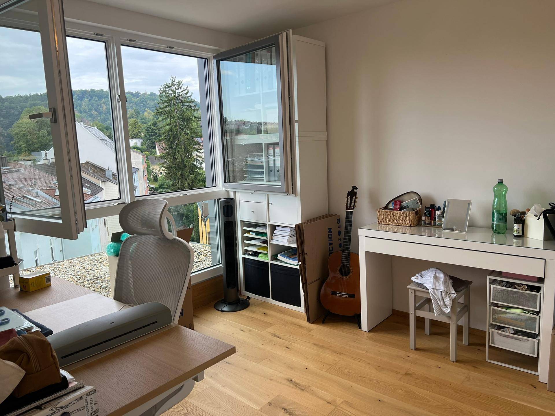 Helles Arbeitszimmer mit großzügigen Fenstern, Schreibtisch und Blick ins Grüne.