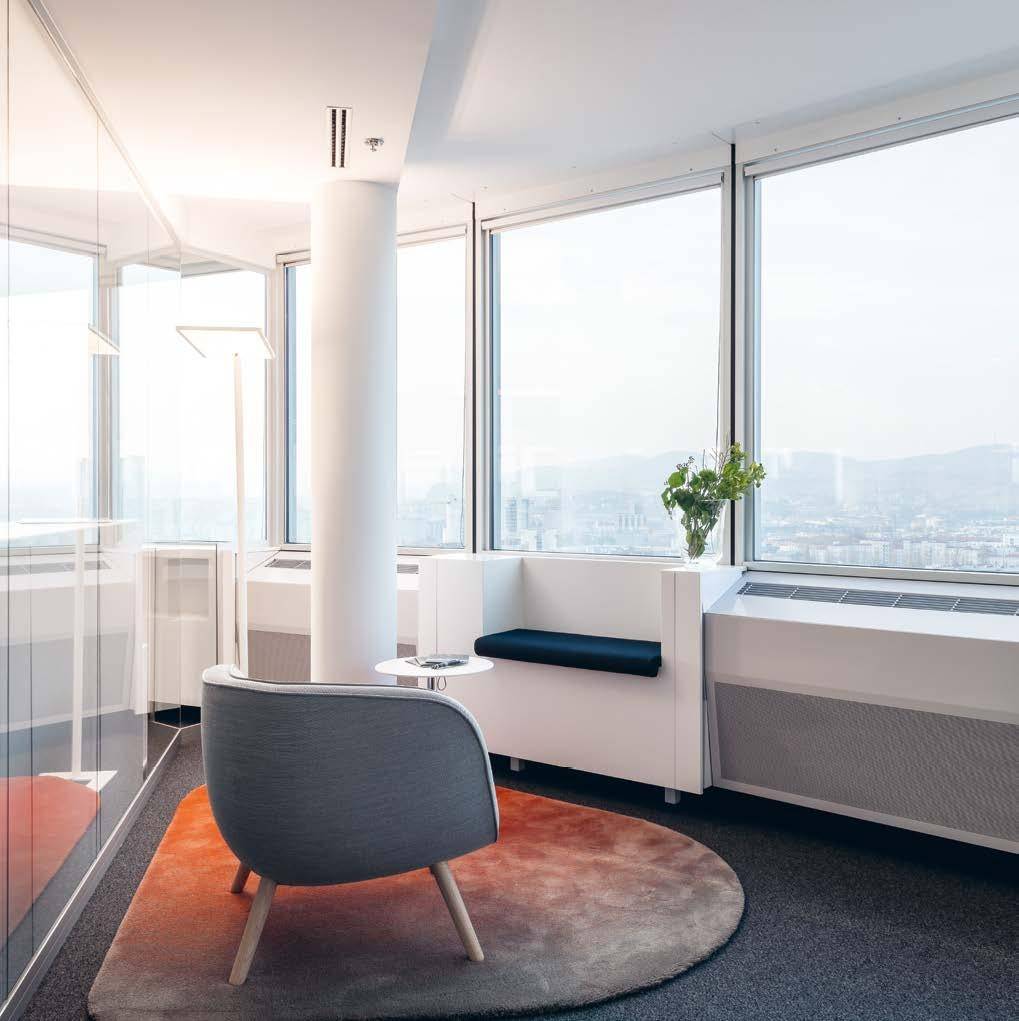 Gemütlicher Loungebereich mit bequemen Sitzgelegenheiten und großen Fenstern, die einen weiten Blick auf die Stadt bieten.