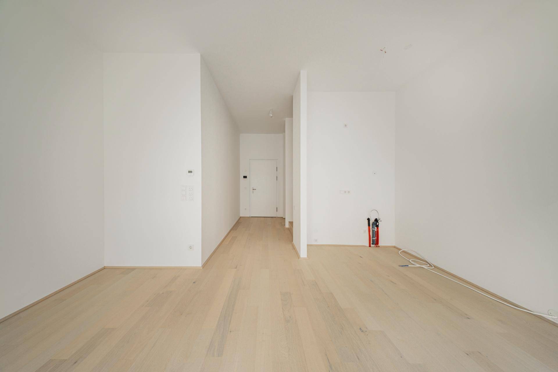 Geräumiger, heller Wohnbereich mit Holzboden und viel Potenzial für individuelle Gestaltung.