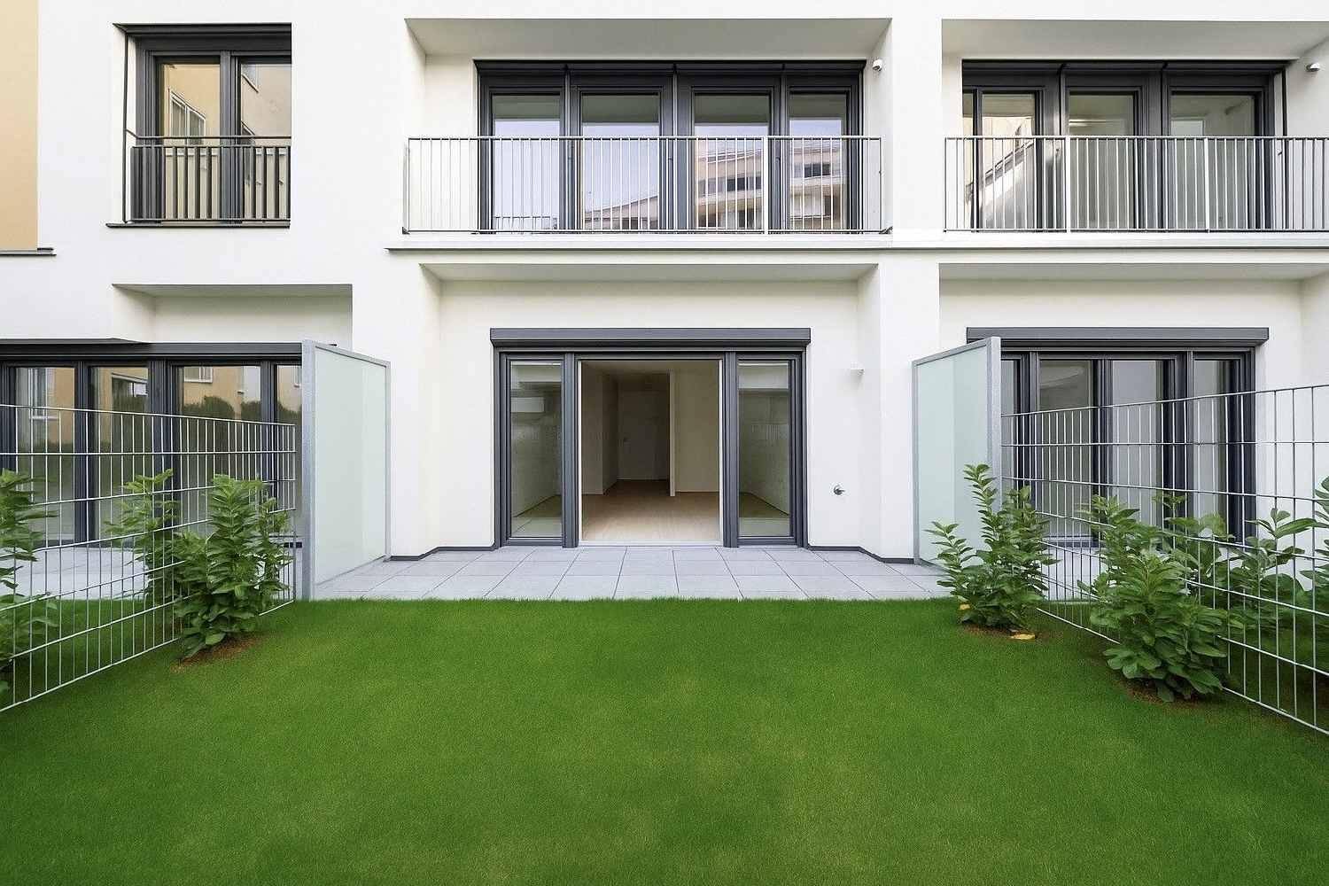 Moderne Erdgeschosswohnung mit direktem Zugang zu einer gefliesten Terrasse und einem gepflegten Gartenbereich.